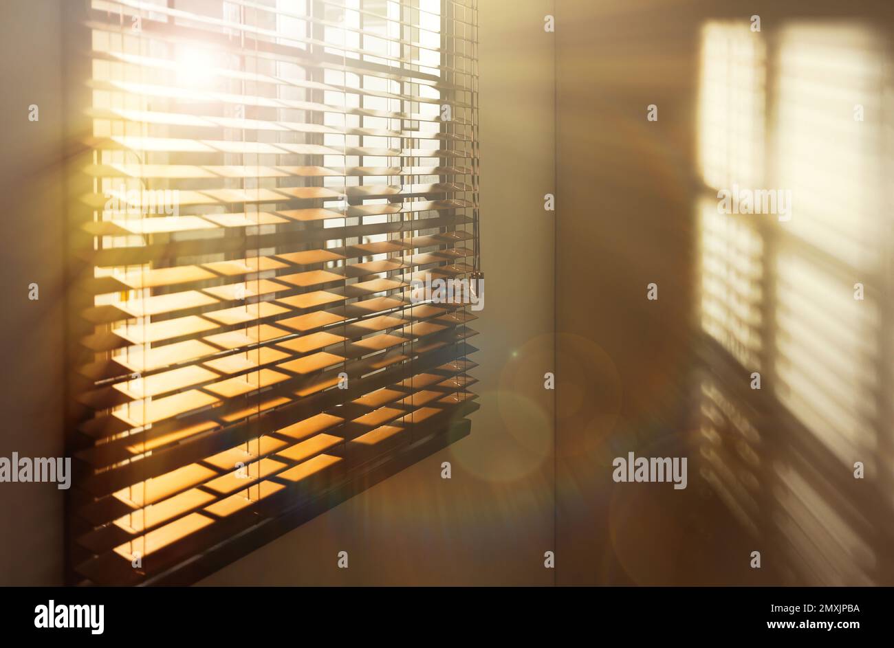 Sole che splende attraverso le tende della finestra in camera Foto Stock