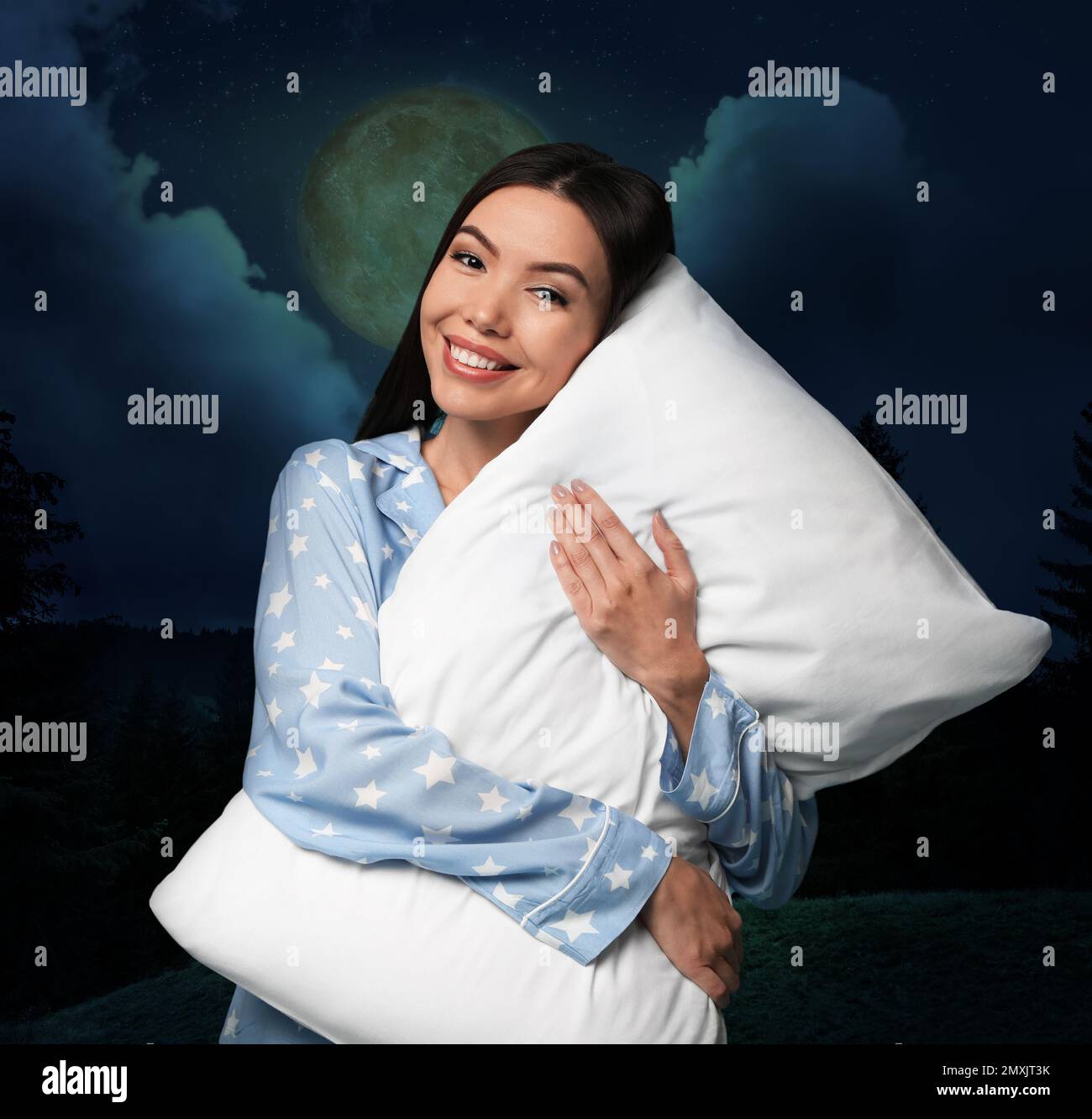 Donna asiatica con cuscino, cielo stellato notturno con luna piena sullo sfondo. Ora di coricarsi Foto Stock