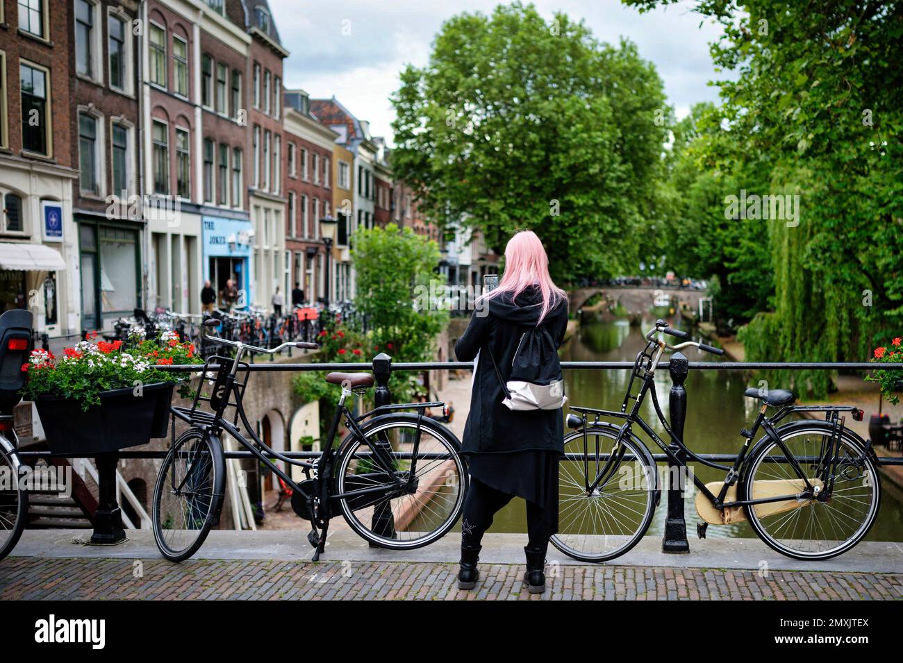 Utrecht, Paesi Bassi - Maggio 24 2022: Una donna scatta una foto con il suo smartphone da un ponte sull'oudegracht di utrecht Foto Stock