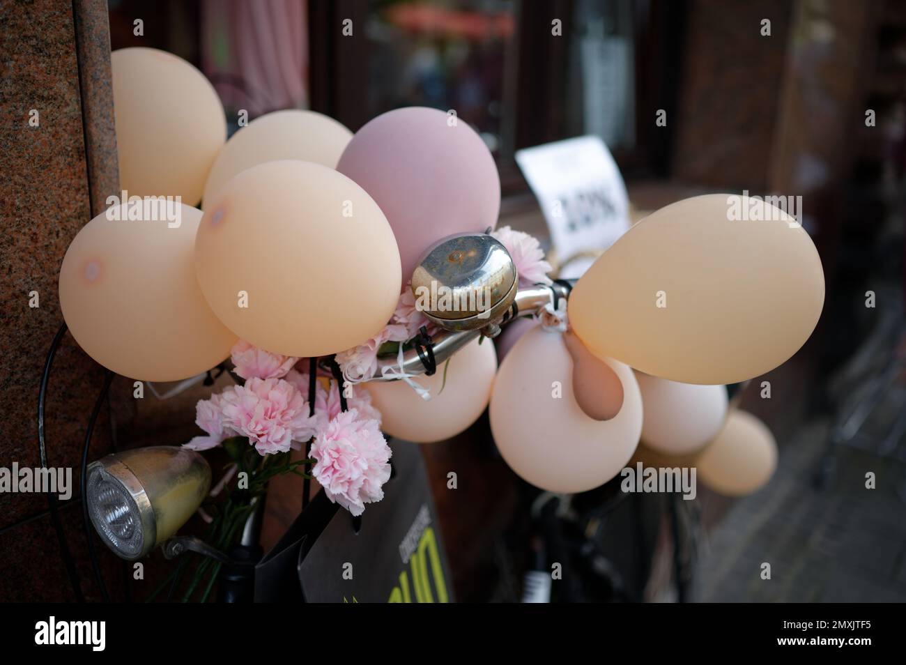 party bike con palloncini pastello e fiori artificiali Foto Stock