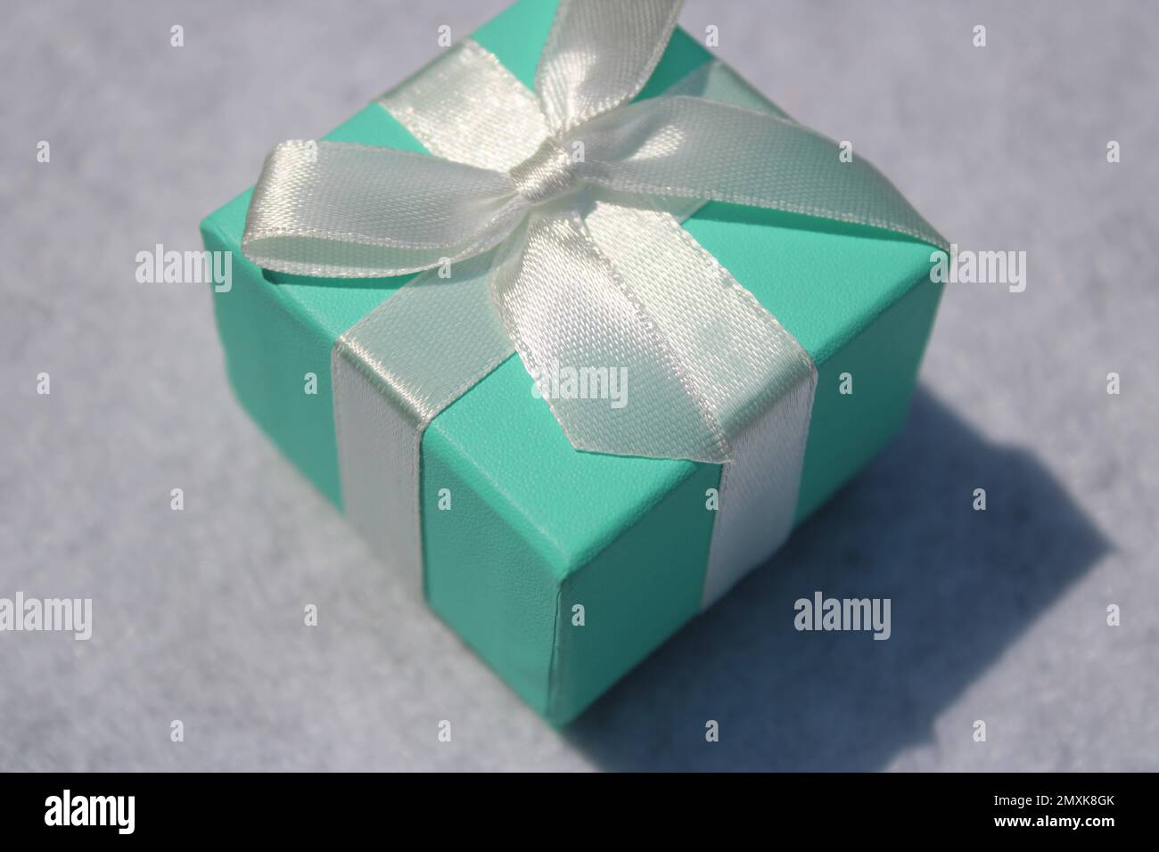 Primo piano della confezione regalo verde schiuma di mare con arco bianco Foto Stock