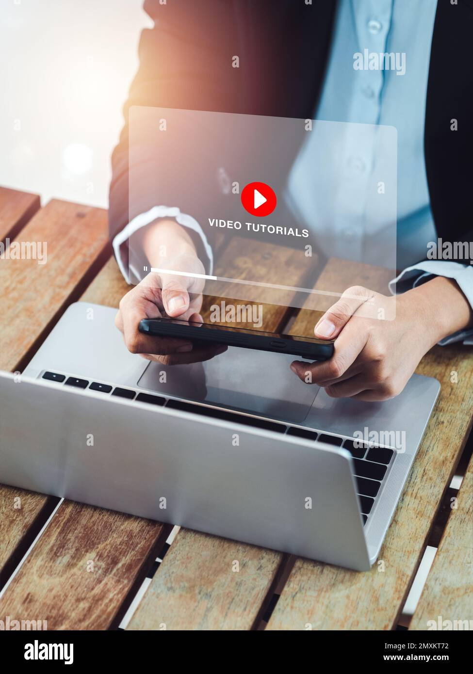 Tutorial video online. Icona rossa di riproduzione sul video tutorial schermo virtuale sullo smartphone mobile vicino al computer portatile, guardando da businessw Foto Stock