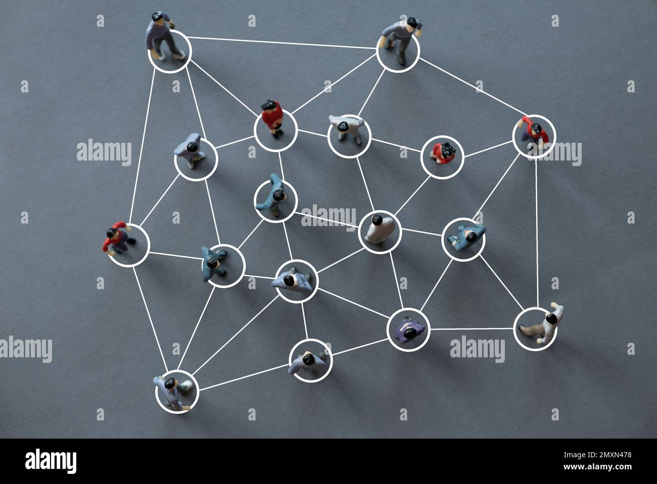 Vista dall'alto delle persone in miniatura in piedi durante la discussione. Concetto di lavoro di squadra, riunione, organizzazione, collaborazione Foto Stock