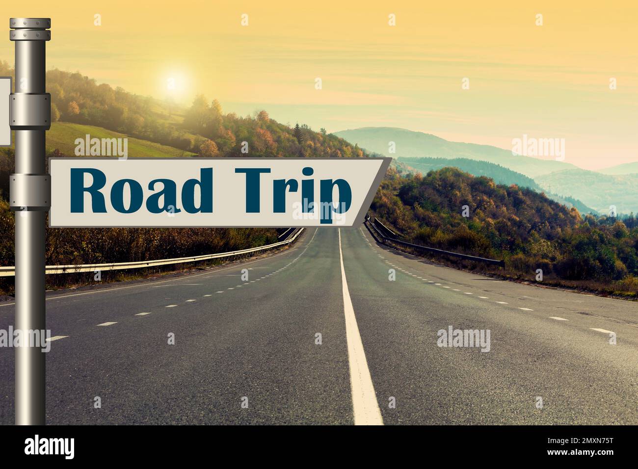 Targa con iscrizione Road trip su strada asfaltata al tramonto Foto Stock