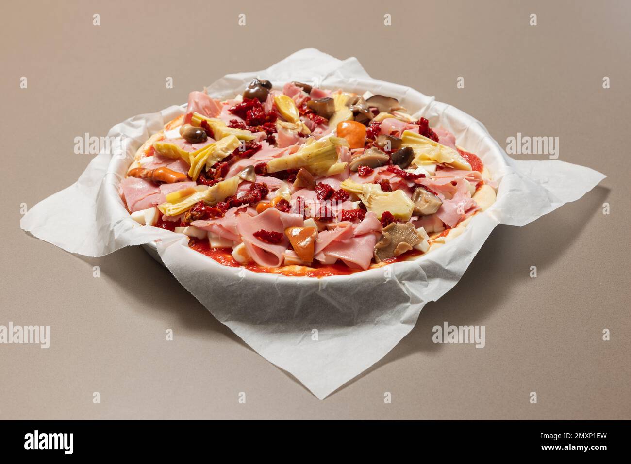 Pizza fatta in casa (capricciosa) con ingredienti classici pronti al forno (focus selettivo) Foto Stock