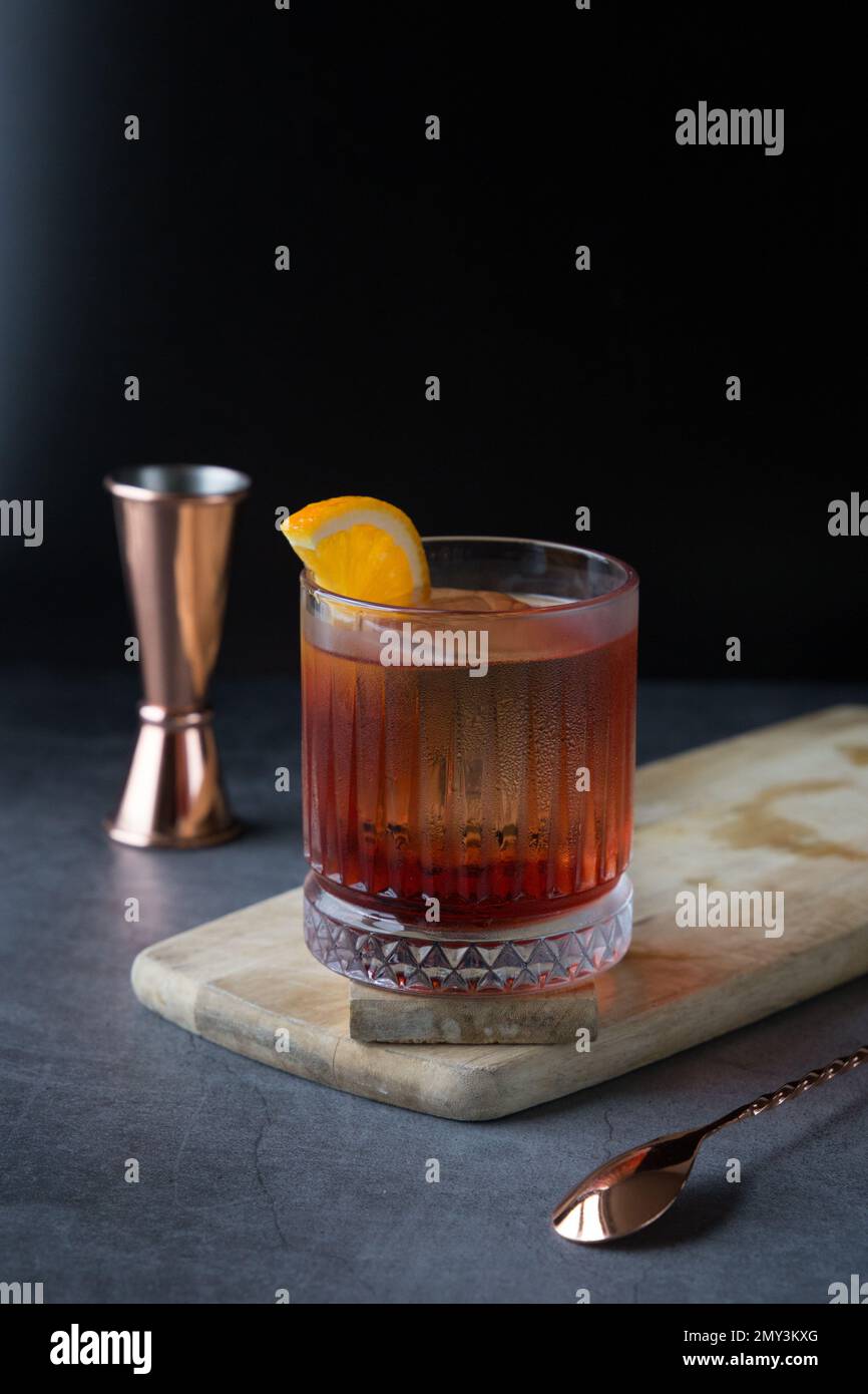 Negroni cocktail drink su sfondo nero e strumenti di barending. Foto Stock