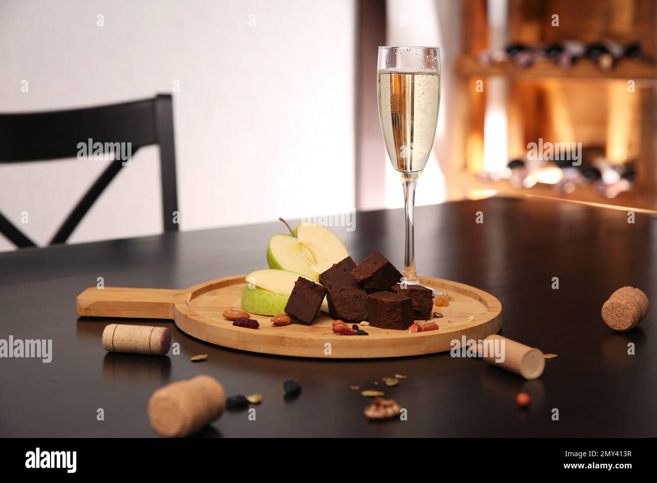 Delizioso formaggio brunost, mela e bicchiere di champagne sul tavolo Foto Stock
