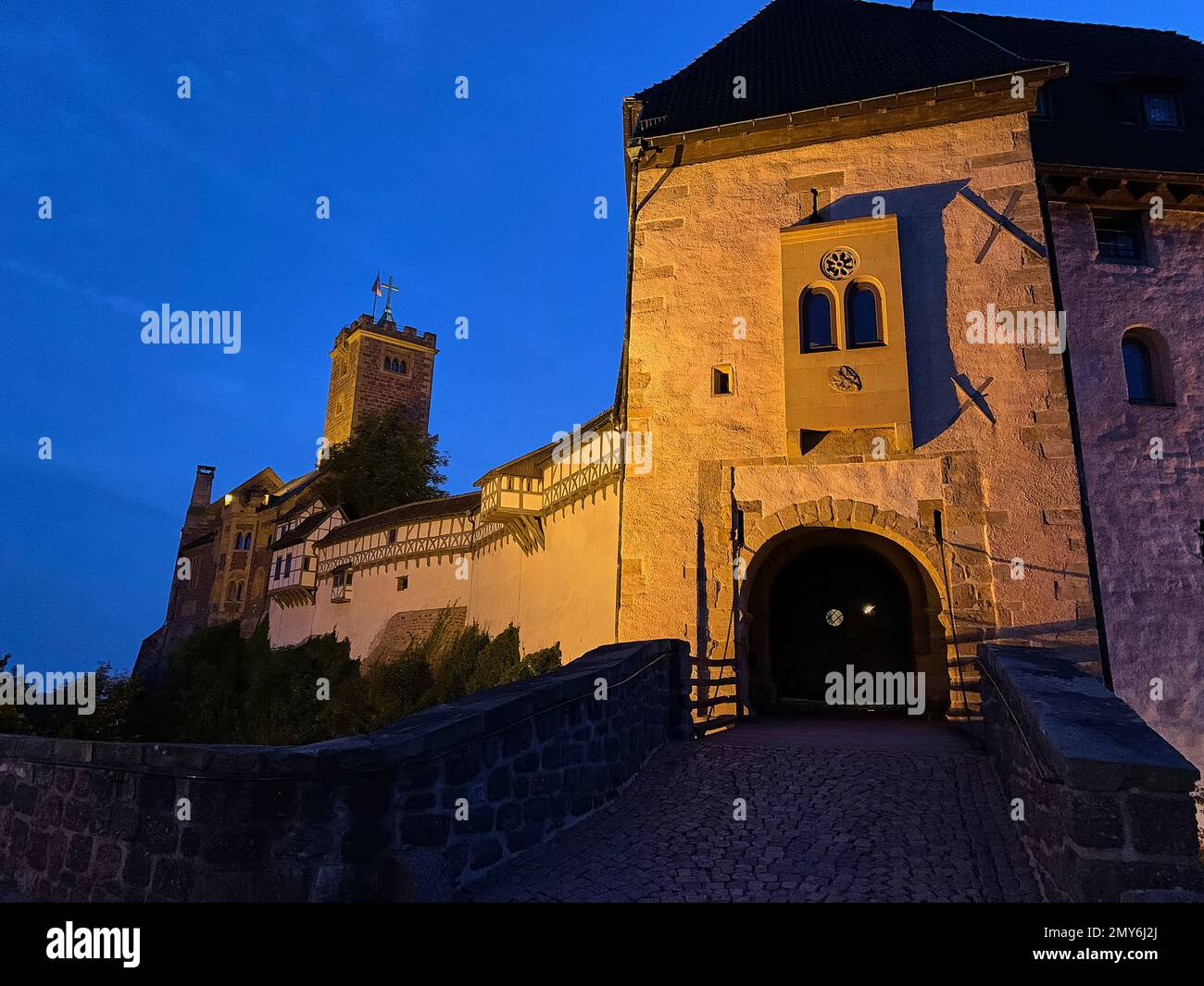 Eisenach, Germania - 09 06 2021: Il vecchio castello tedesco di Wartburg di Eisenach illuminato di notte, torreggiante sopra la città vecchia, era il rifugio del p Foto Stock