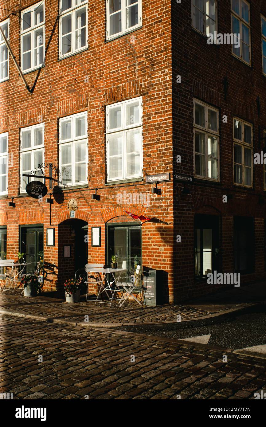 Little Cafe su una facciata di un edificio in mattoni con il sole invernale che colpisce a Copenhagen Foto Stock