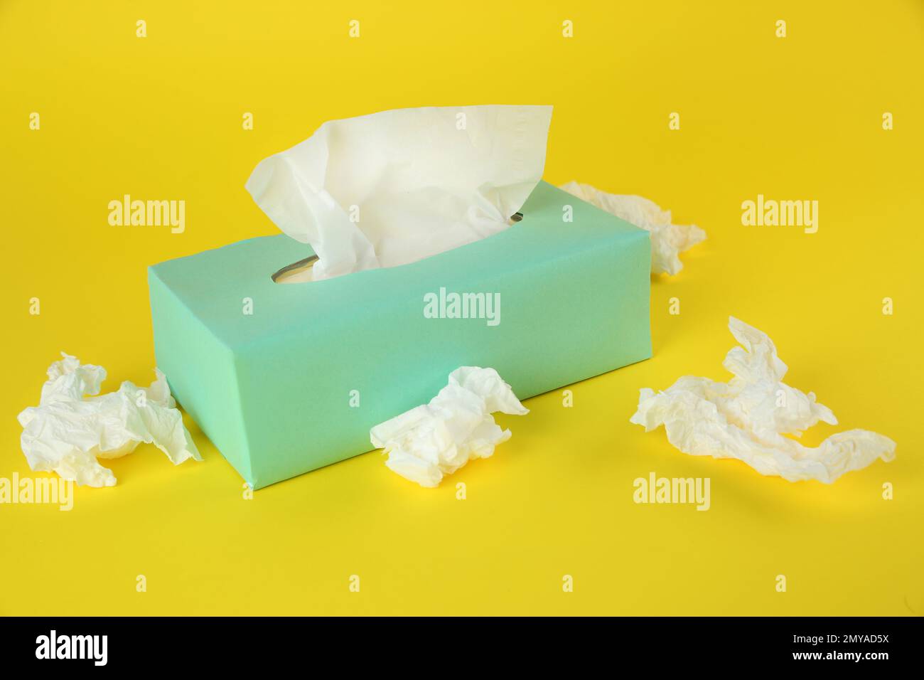 Fazzolettini di carta usati e scatola su sfondo giallo Foto stock - Alamy