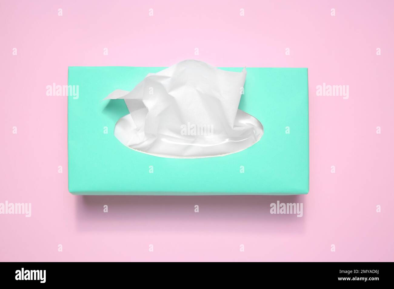 Scatola con fazzolettini di carta su sfondo rosa, vista dall'alto Foto Stock