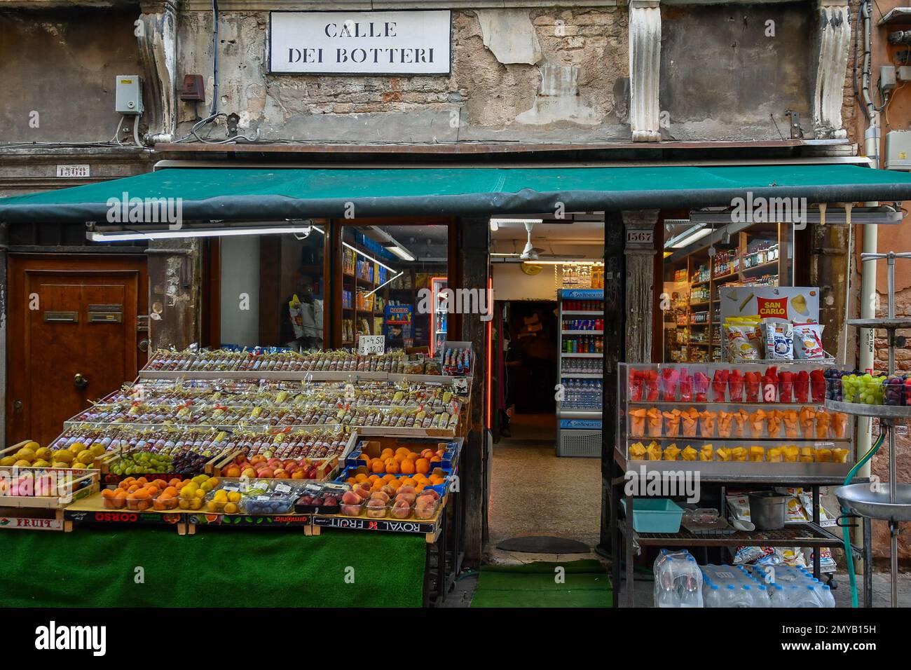 Esterno di un negozio di alimentari con frutta fresca e Macedonia in tazze di plastica da asporto in Calle dei Botteri, Venezia, Veneto, Italia Foto Stock