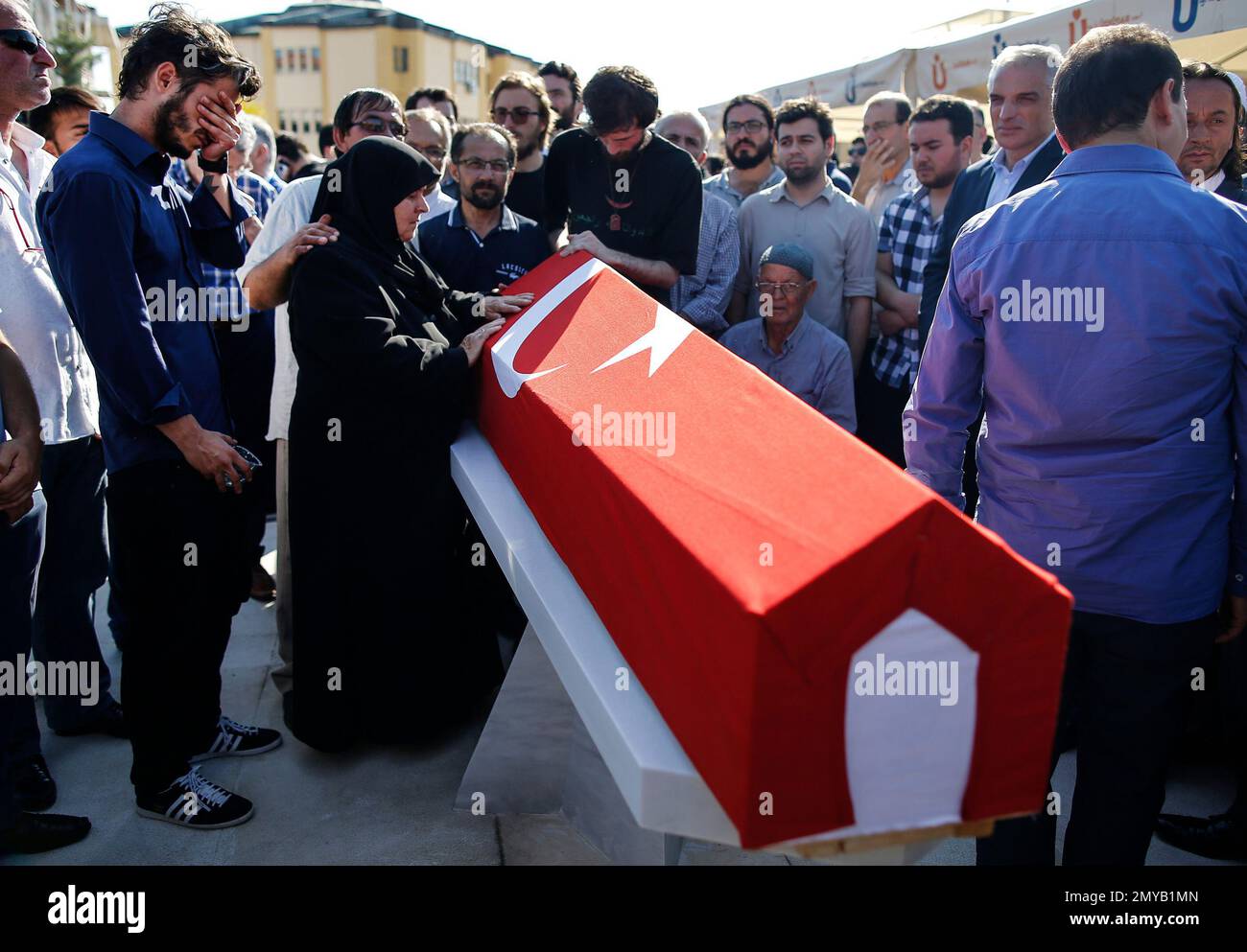 Relatives mourn over the Turkish flag-draped coffin of one of the people killed while protesting the attempted coup against Turkey's government, in Istanbul, Sunday, July 17, 2016. Rather than toppling Turkey's strongman president, a failed military coup appears to have bolstered Turkish President Recep Tayyip Erdogan's immediate grip on power and boosted his popularity. (AP Photo/Emrah Gurel) Foto Stock