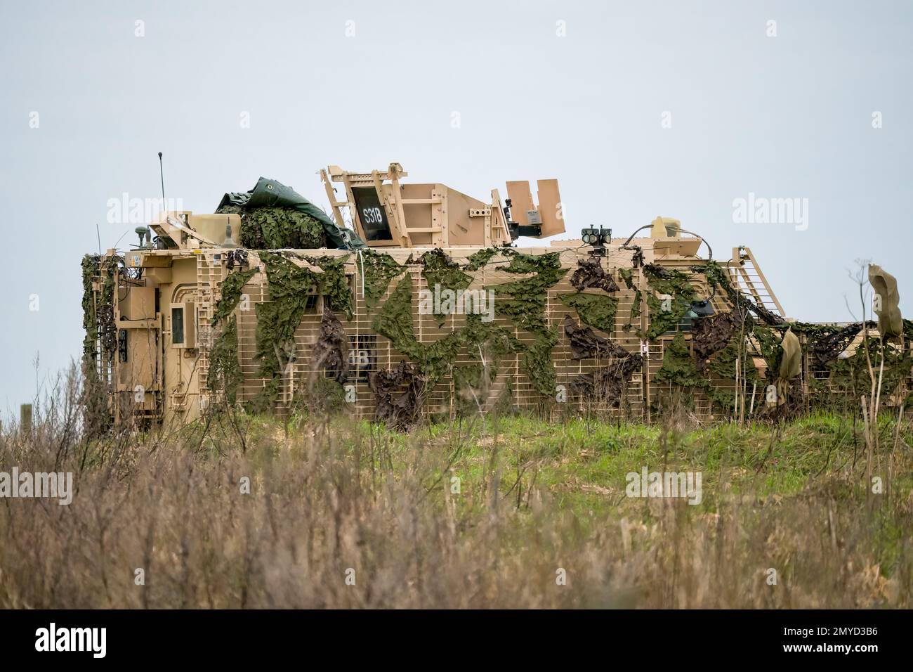Primo piano di un veicolo di pattuglia protetto da Mastiff dell'esercito britannico sotto una rete verde di mimetizzazione Foto Stock