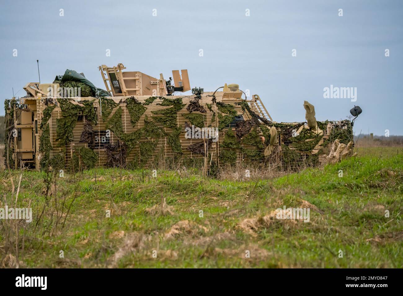 Primo piano di un veicolo di pattuglia protetto da Mastiff dell'esercito britannico sotto una rete verde di mimetizzazione Foto Stock