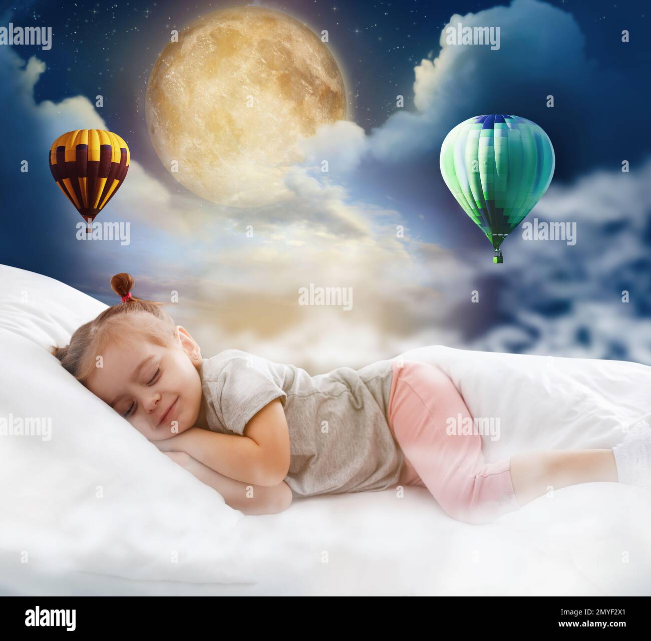 Carina bambina che dorme a letto. Luna piena e mongolfiere in cielo nuvoloso - sogni dolci Foto Stock