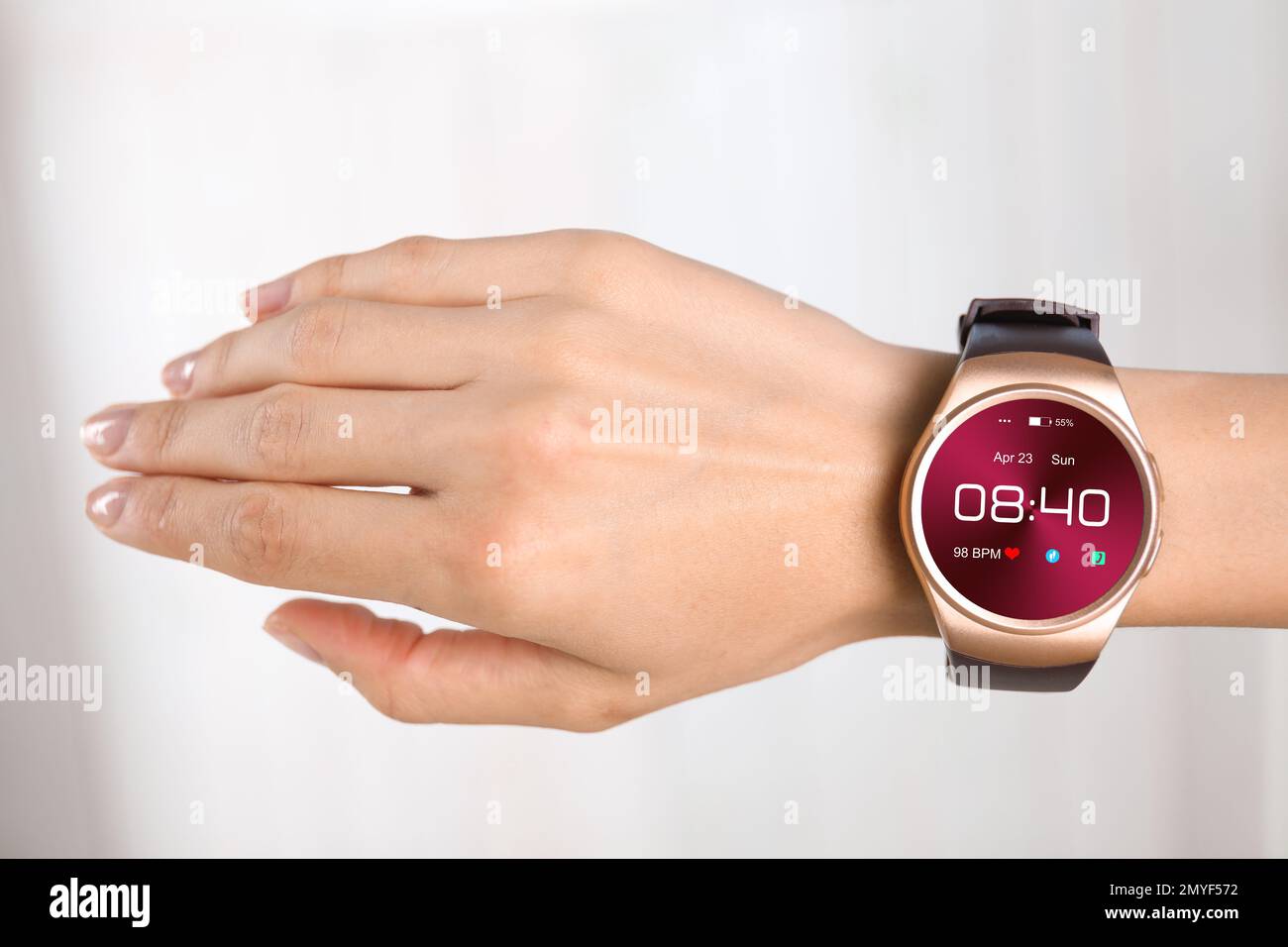 Donna con orologio intelligente che visualizza ora, data e frequenza cardiaca, primo piano Foto Stock