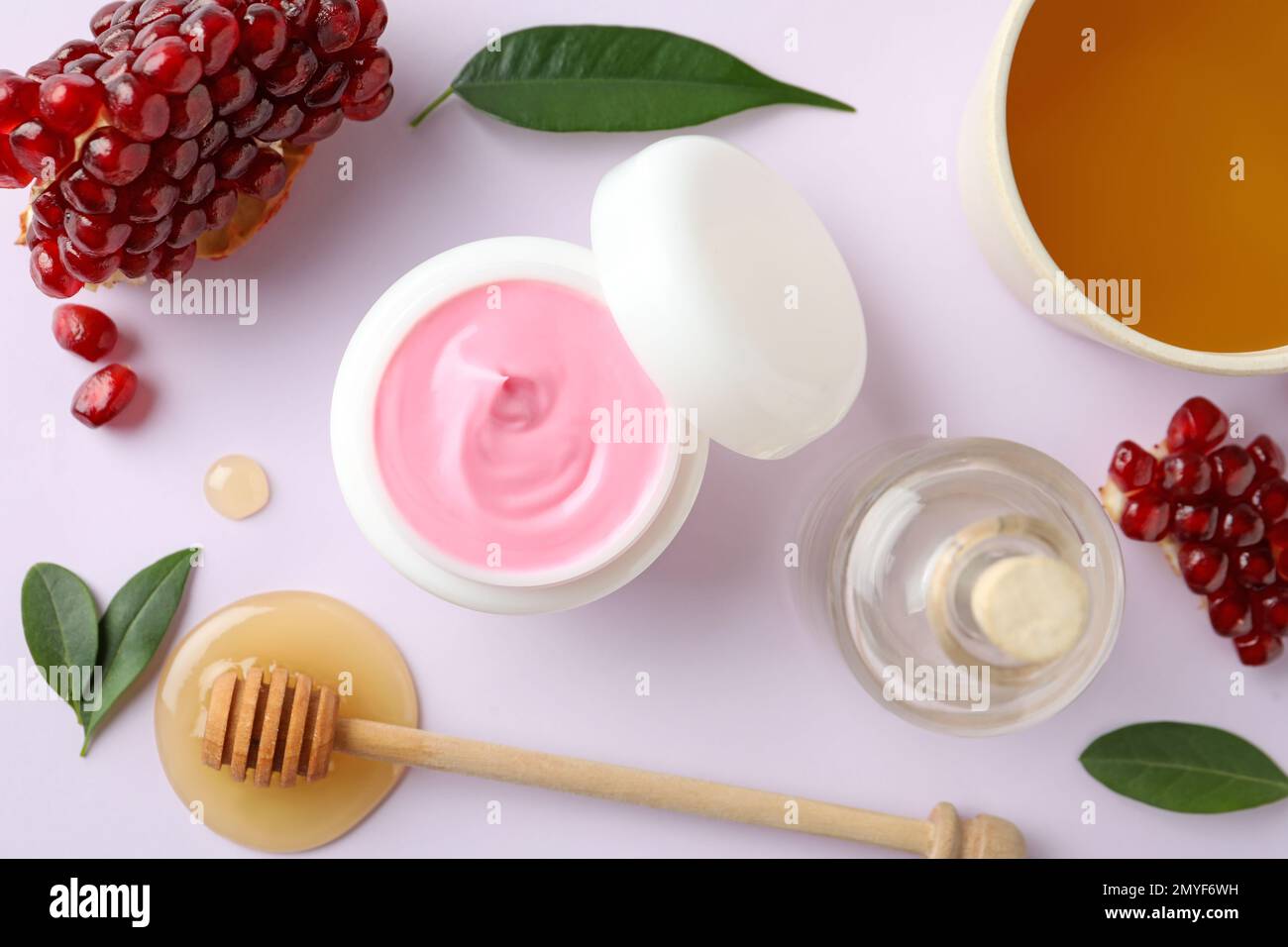 Composizione con maschera naturale fatta in casa, melograno e ingredienti su sfondo bianco, vista dall'alto Foto Stock