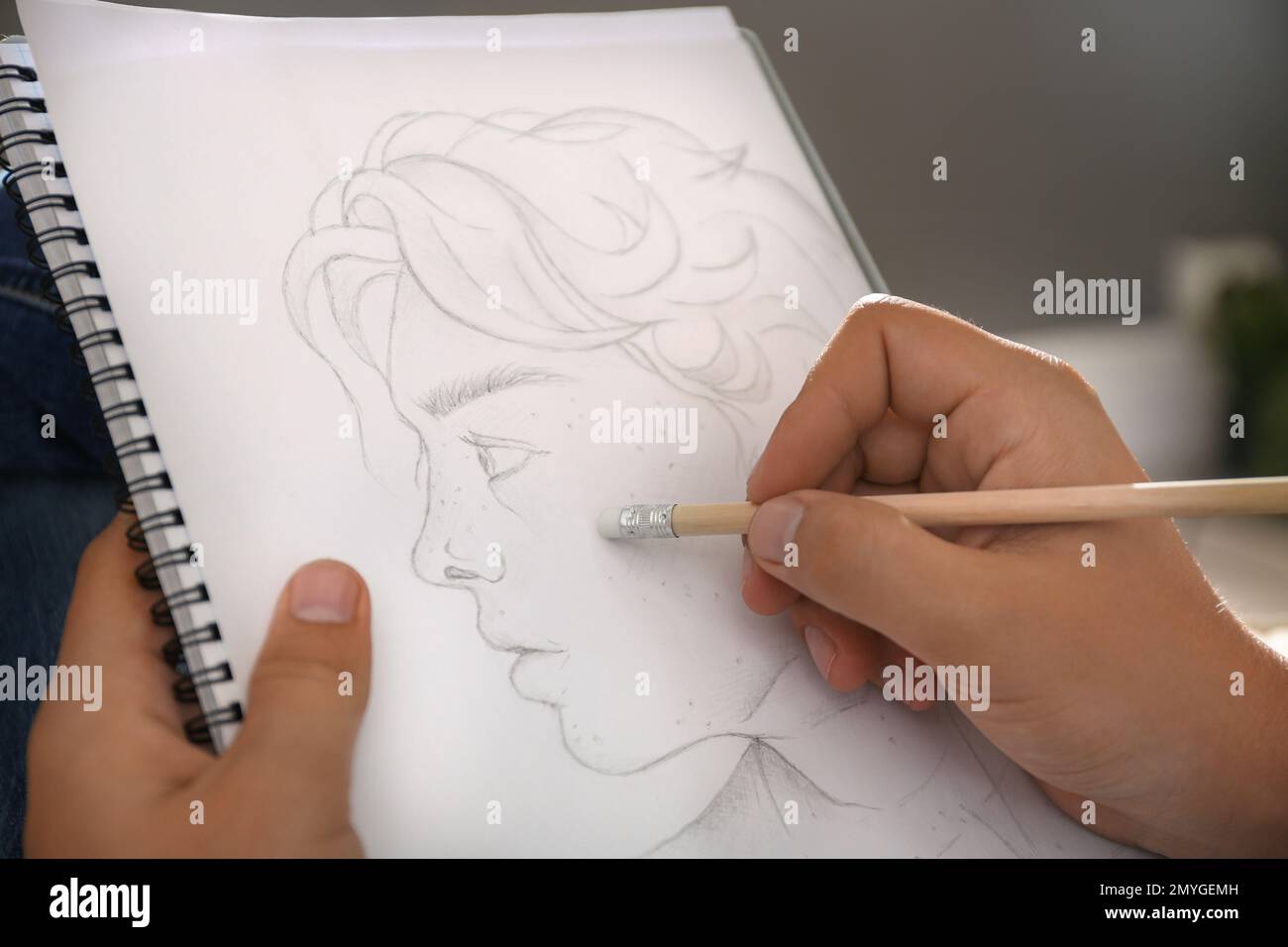 Uomo disegno ritratto con matita in blocco note interni, primo piano Foto Stock