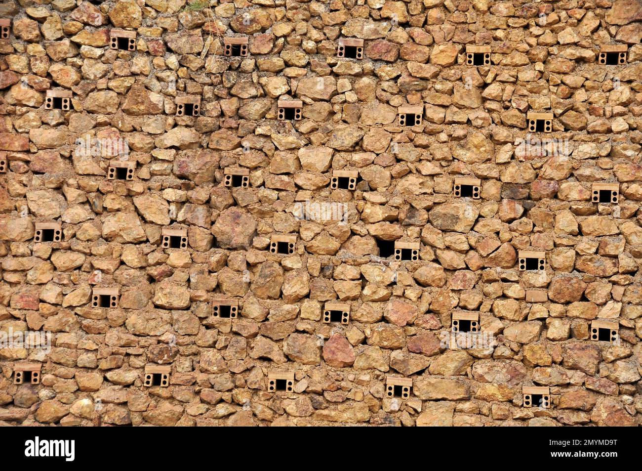 Muro di pietra naturale di una miniera con fori di ventilazione Foto Stock