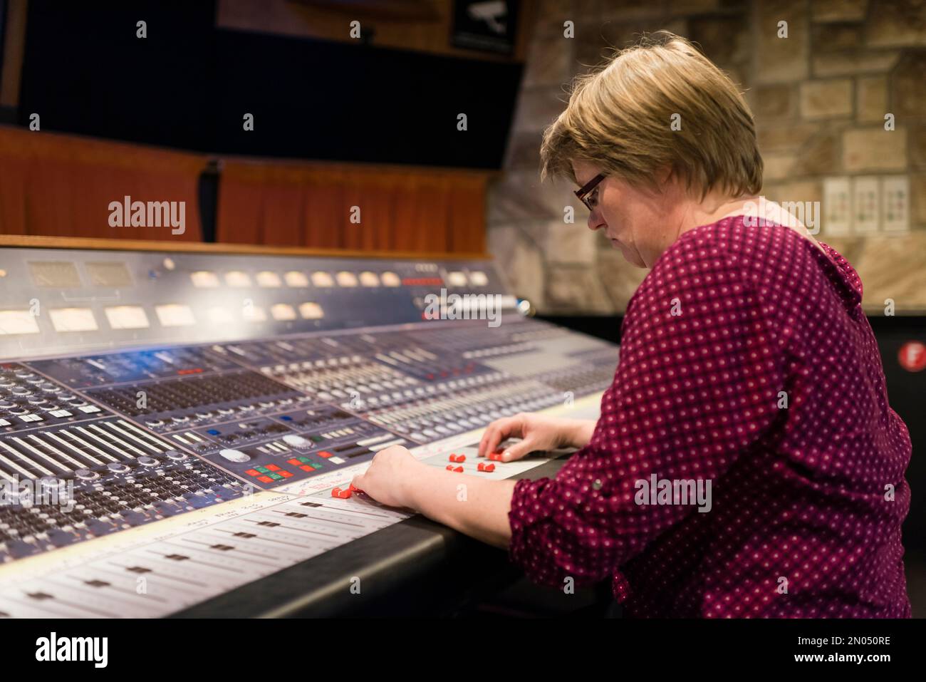 Una donna è seduta in uno studio professionale di registrazione audio d'epoca analogico. Foto scattata al Mountain View Studio di Montreux, Svizzera. Foto Stock
