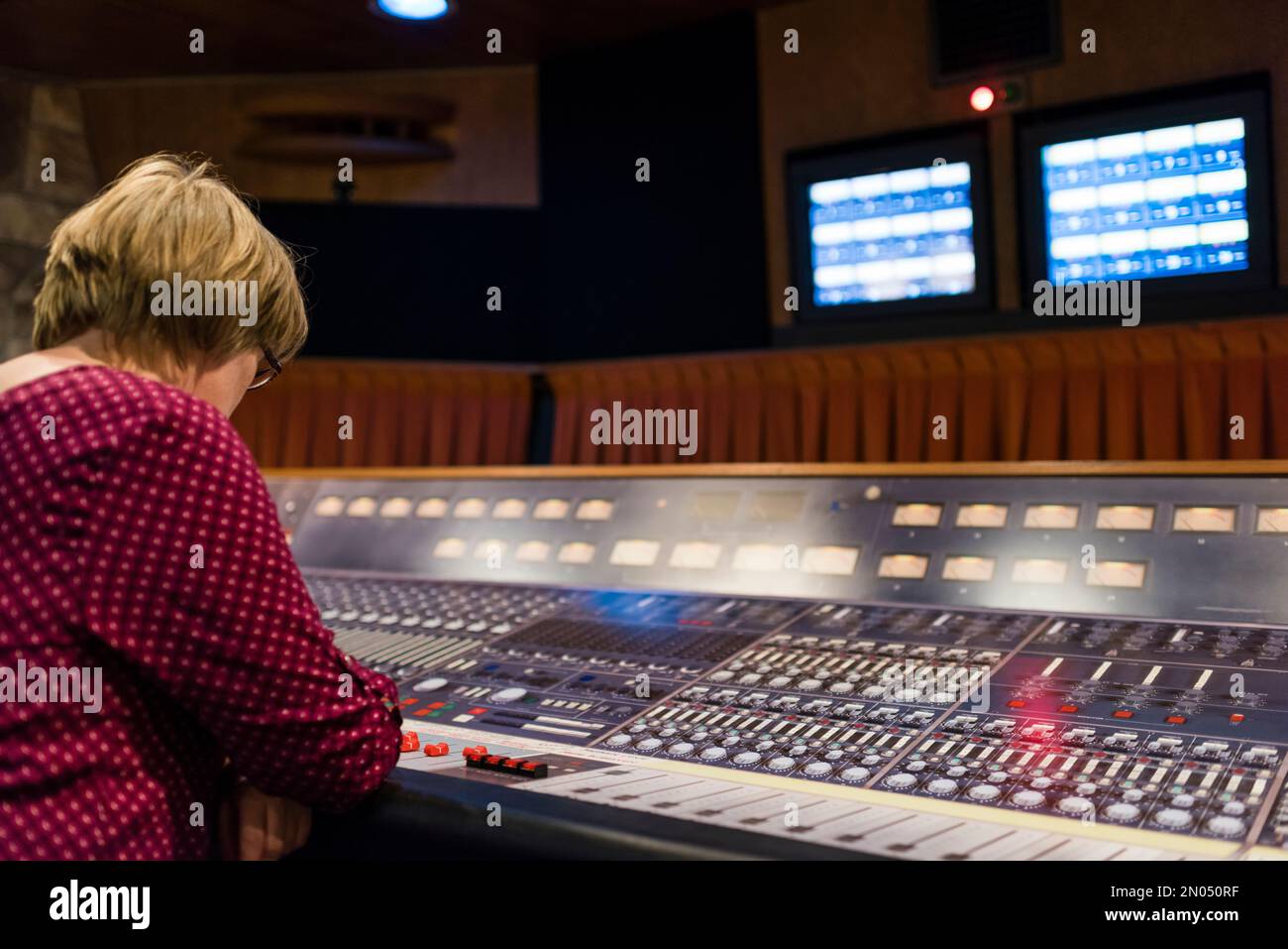 Una donna è seduta in uno studio professionale di registrazione audio d'epoca analogico. Foto scattata al Mountain View Studio di Montreux, Svizzera. Foto Stock