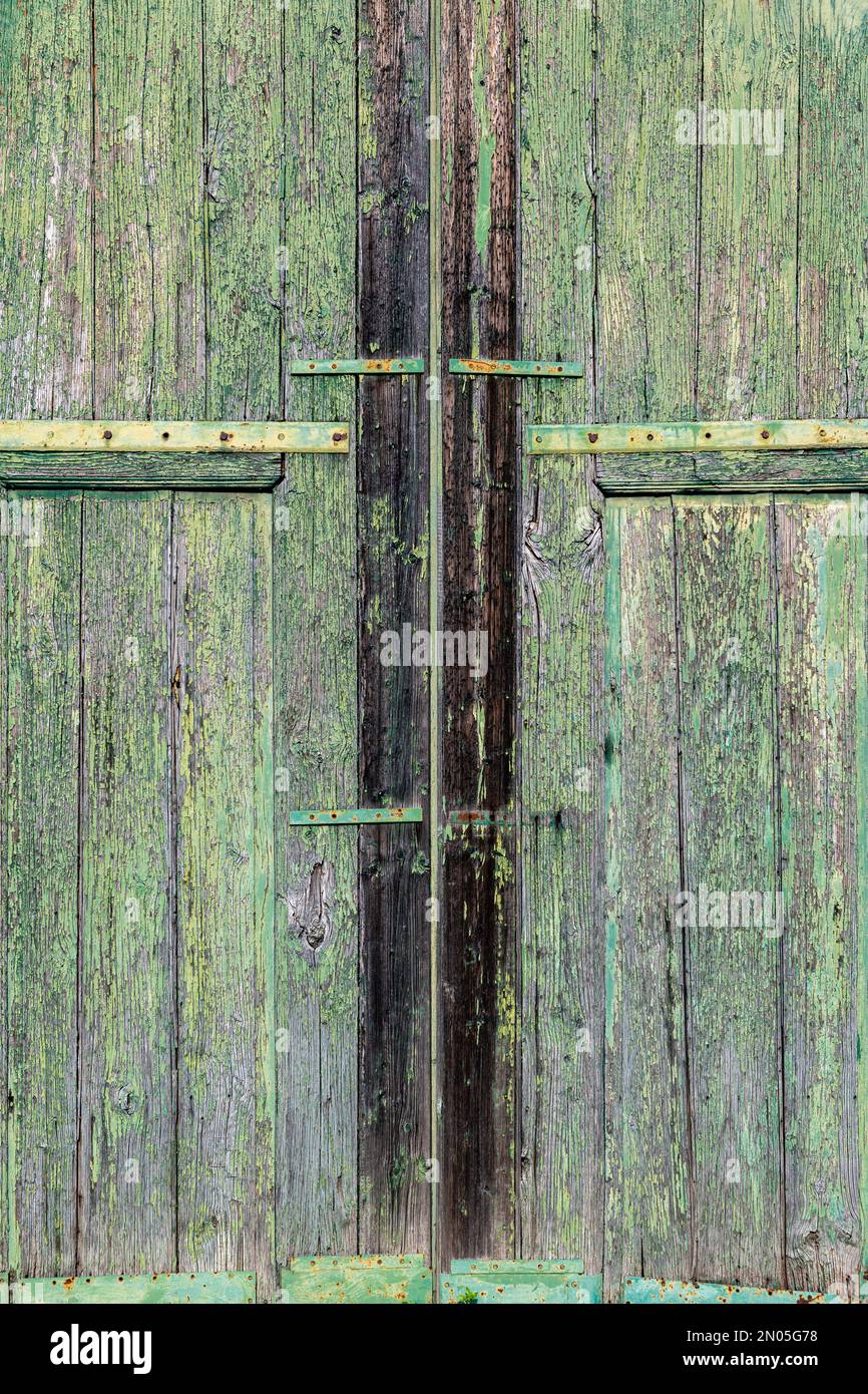 Un paio di porte in legno vecchio capannone, mal stagionato e decorato con vernice verde peeling (Sicilia) Foto Stock
