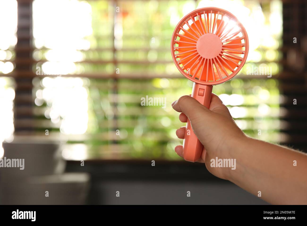 Vista in primo piano del bambino piccolo con ventilatore portatile a casa,  spazio per il testo. Caldo estivo Foto stock - Alamy