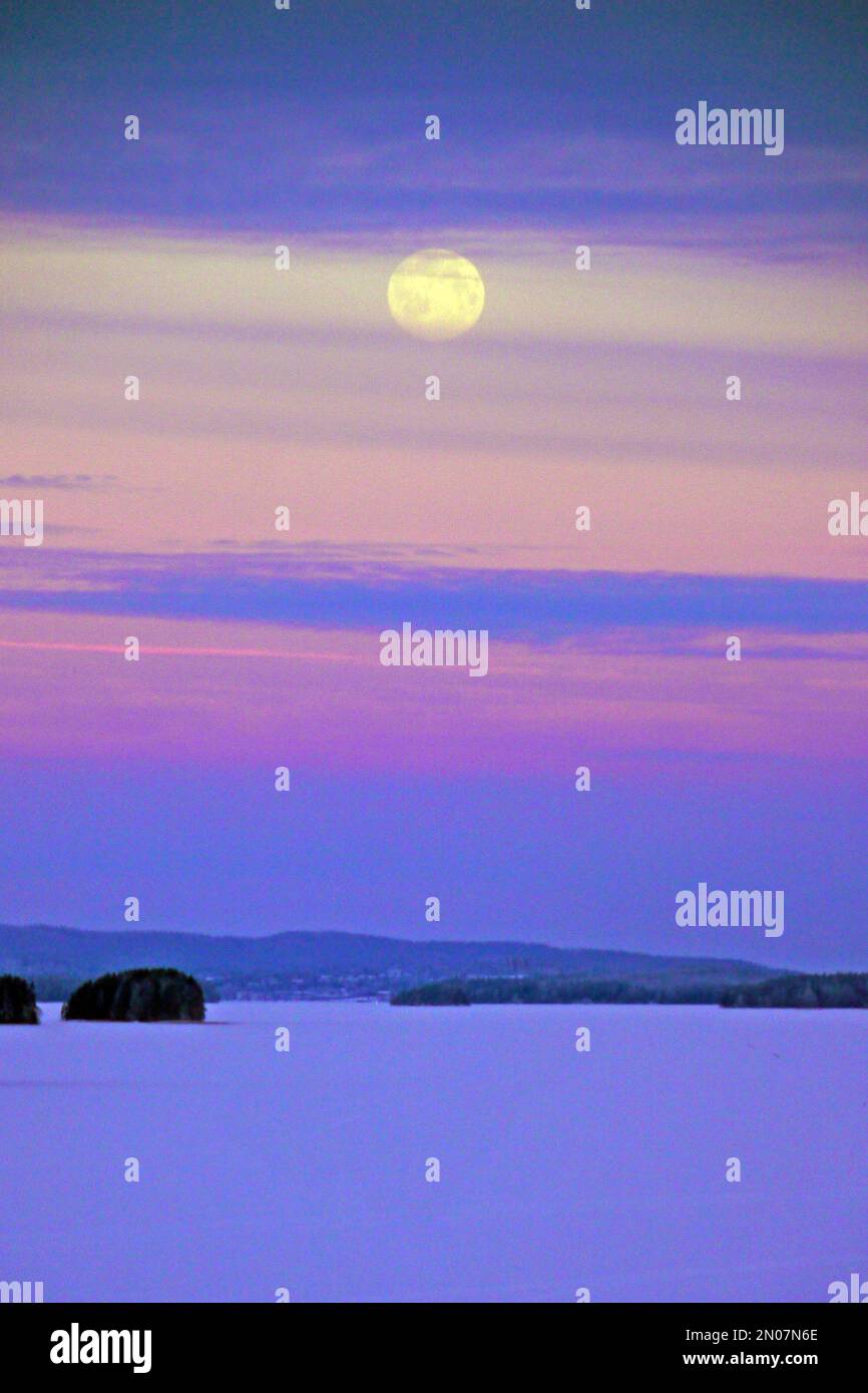 Febbraio luna piena sul lago Kallavesi. Vehmersalmi, Kuopio, Finlandia, 2023-02-05 08:40 +02. Temperatura -12 °C, vento S 3 m/s. Foto Stock