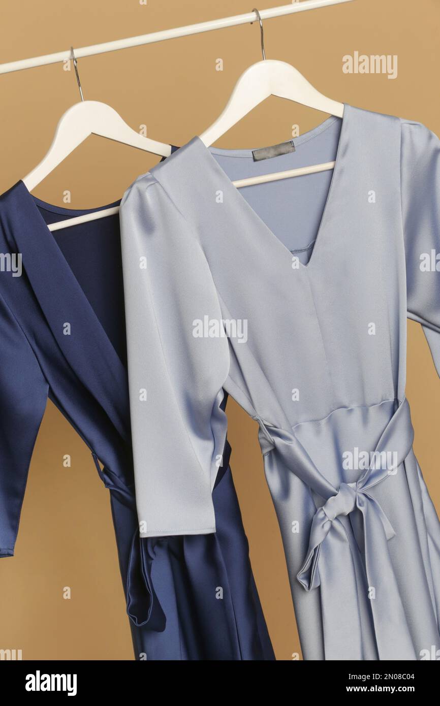 Abiti da donna. Appendiabiti con eleganti ed eleganti abiti in seta blu in atelier di moda. Pezzi di moda senza tempo di buona qualità. Foto Stock