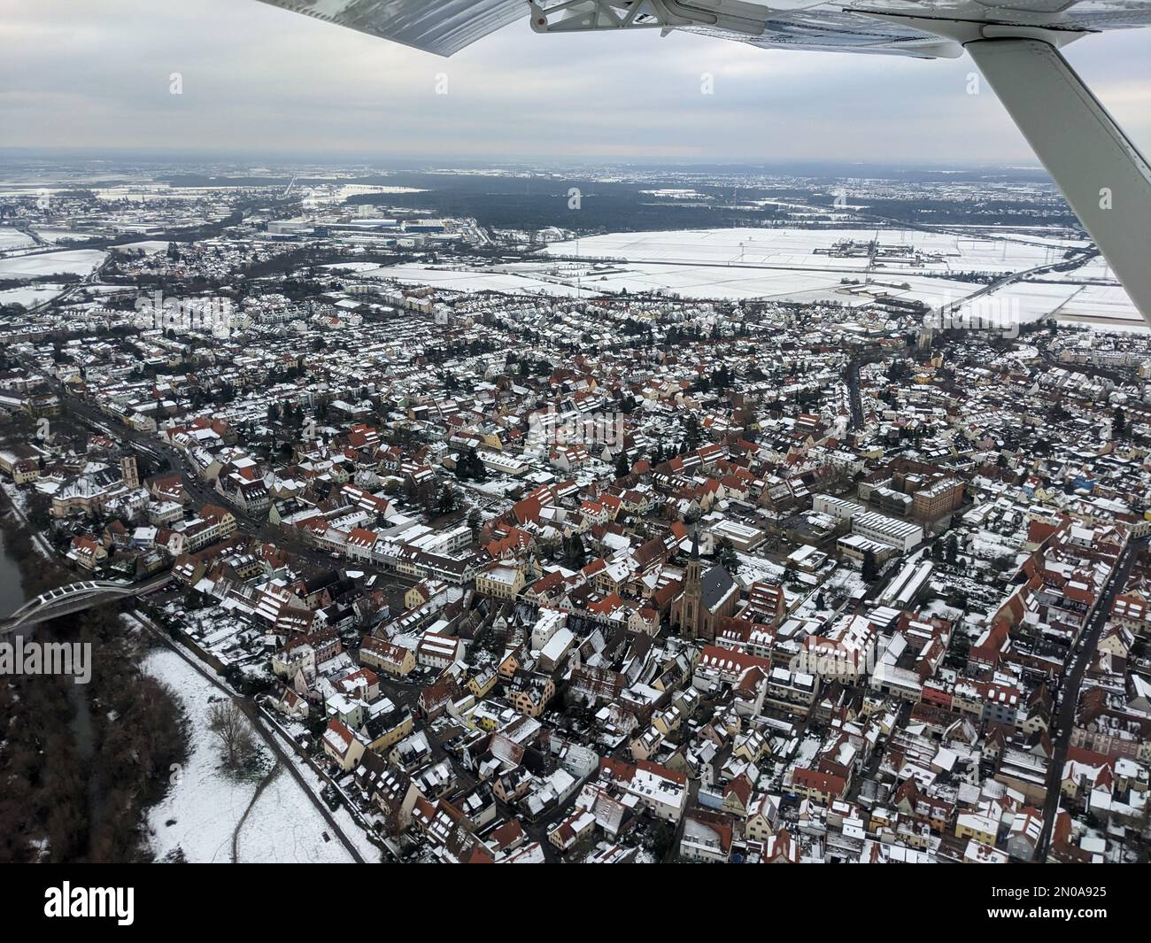 Vista aerea della città di Seckenheim a Mannheim durante l'inverno coperto di neve. Aereo leggero che sorvola la città dopo la partenza dall'aereo regionale Foto Stock