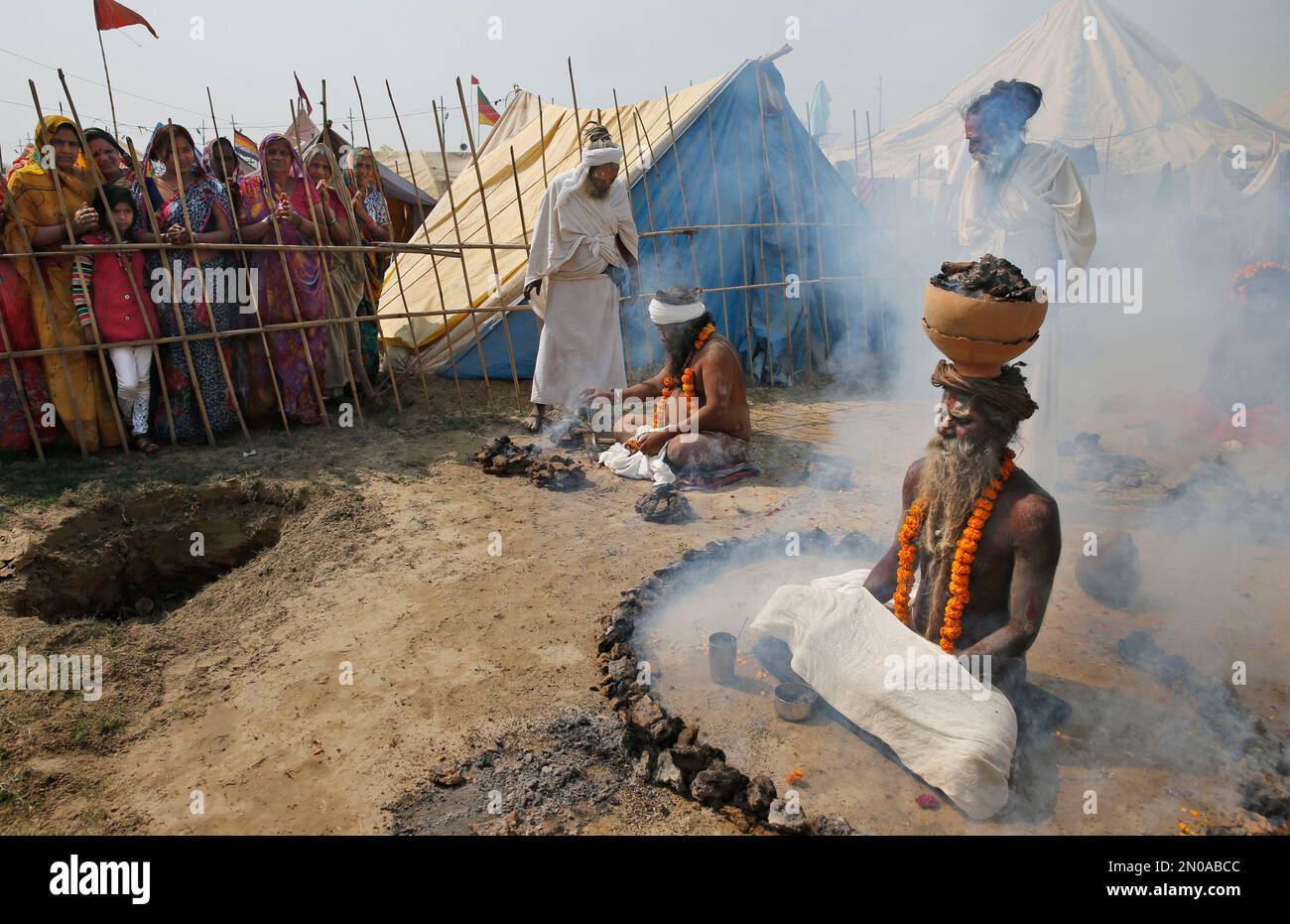 Indian Hindu devotees, left, watch an Indian Sadhu, Hindu holy man, as ...