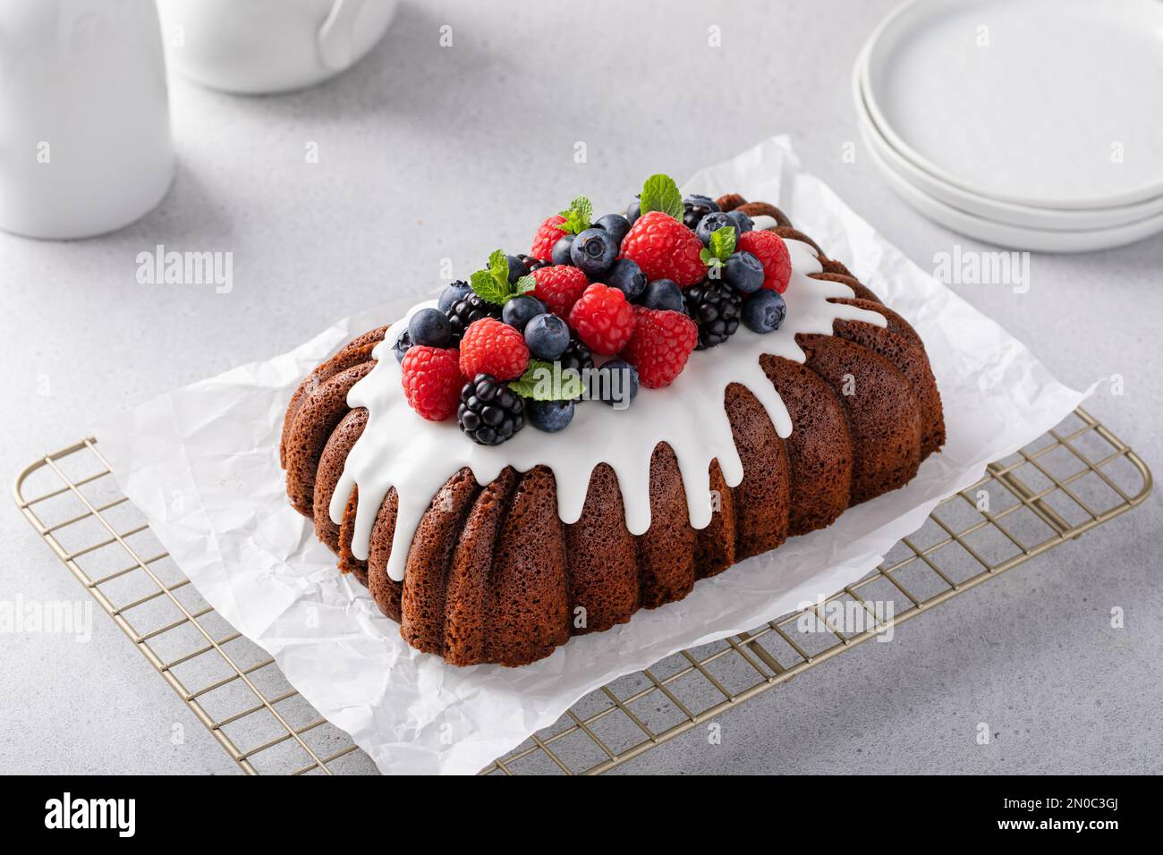 Torta al cioccolato o pane veloce con glassa di formaggio cremoso e frutti di bosco freschi Foto Stock