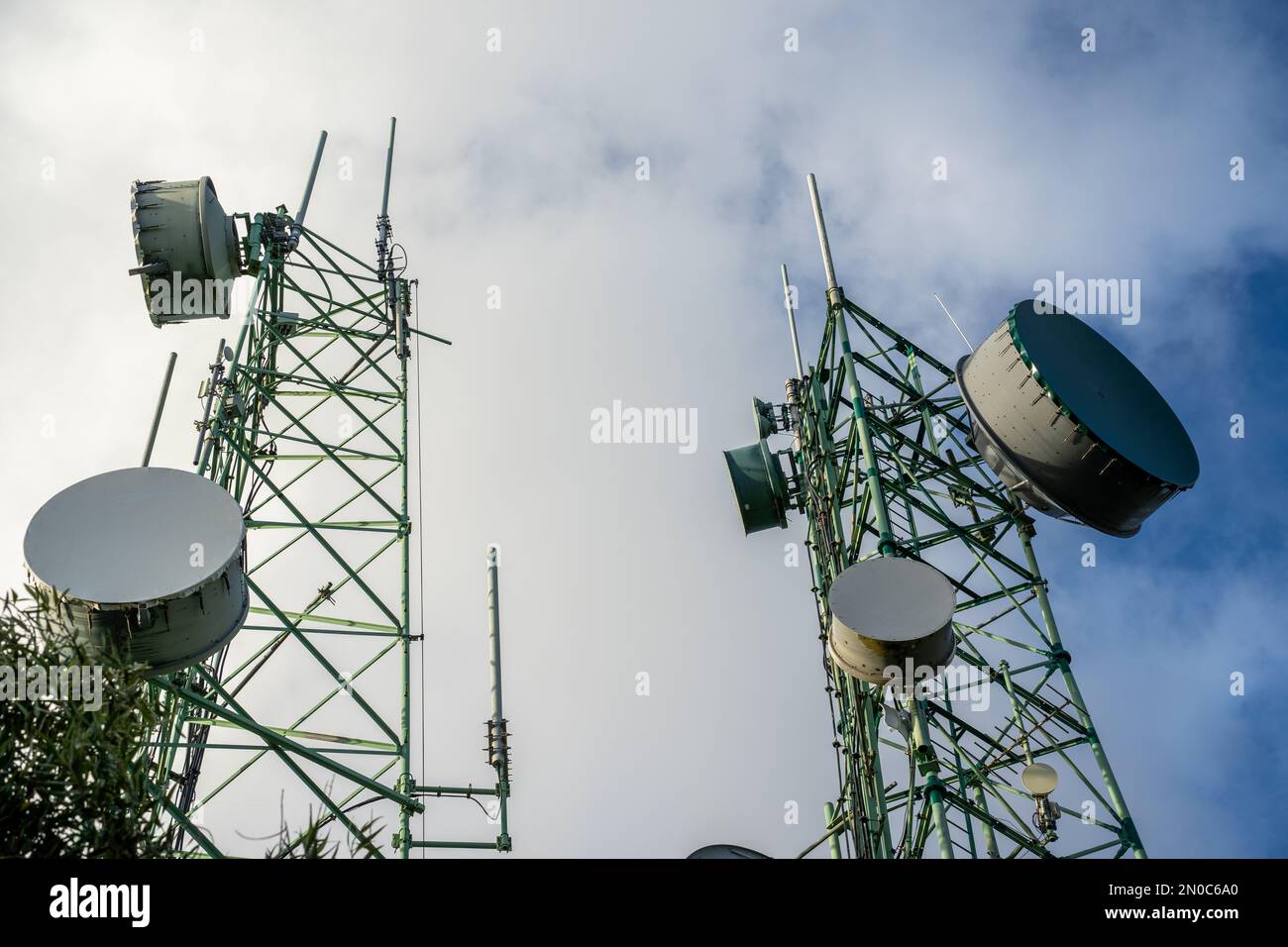 Immagine a basso angolo di una torre con collegamenti a microonde e antenne di trasmissione TV Foto Stock