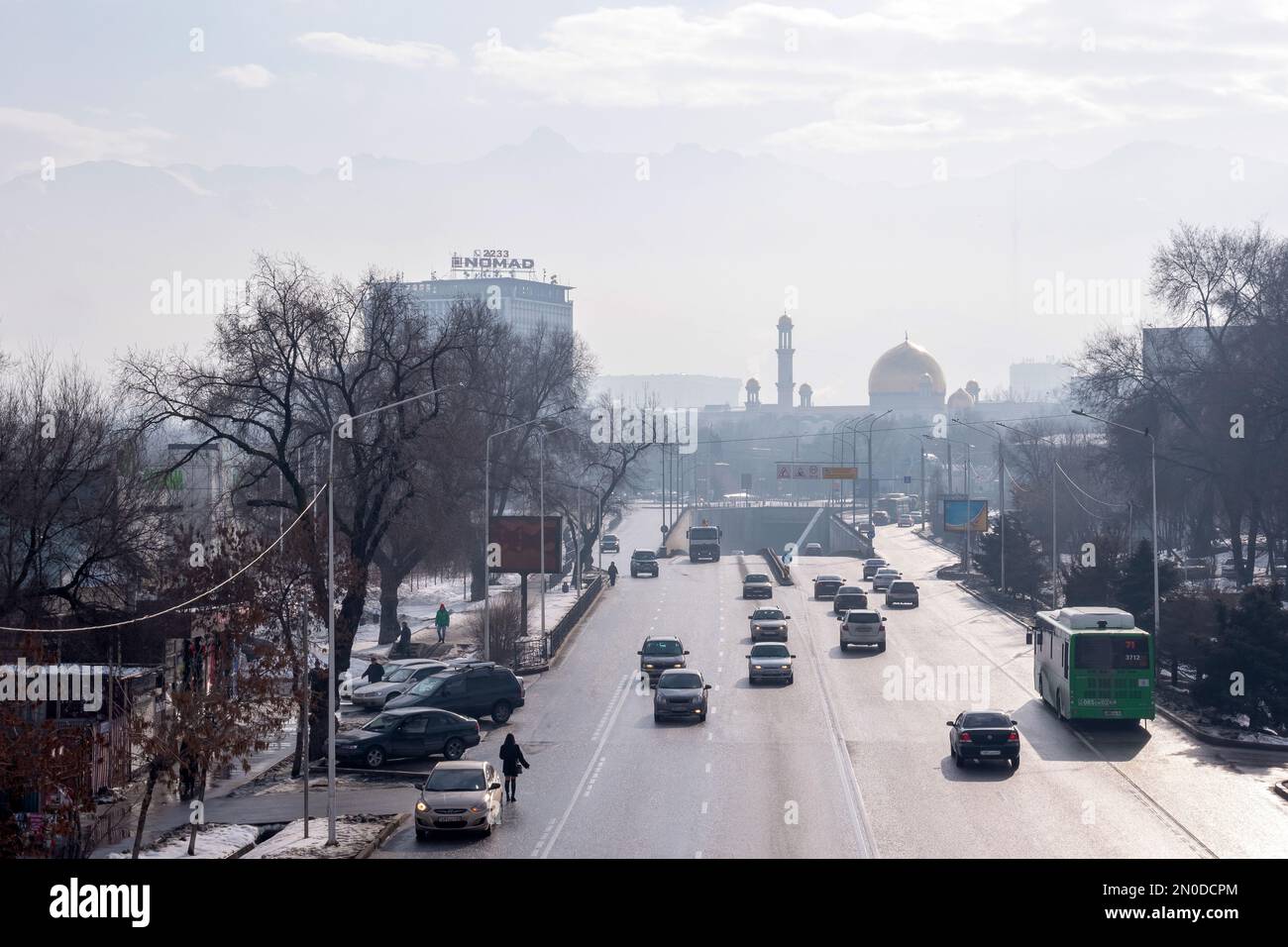 Almaty, Kazakistan - 07 gennaio 2023: Vista aerea invernale della strada della città, le montagne sullo sfondo sono nascoste dallo smog Foto Stock