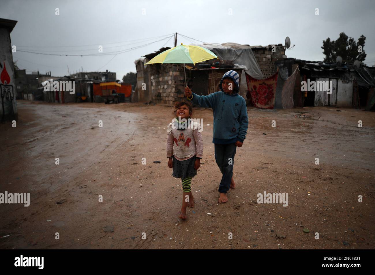 I bambini palestinesi giocano durante una giornata di pioggia in una zona povera della città di Gaza. Palestina. Foto Stock