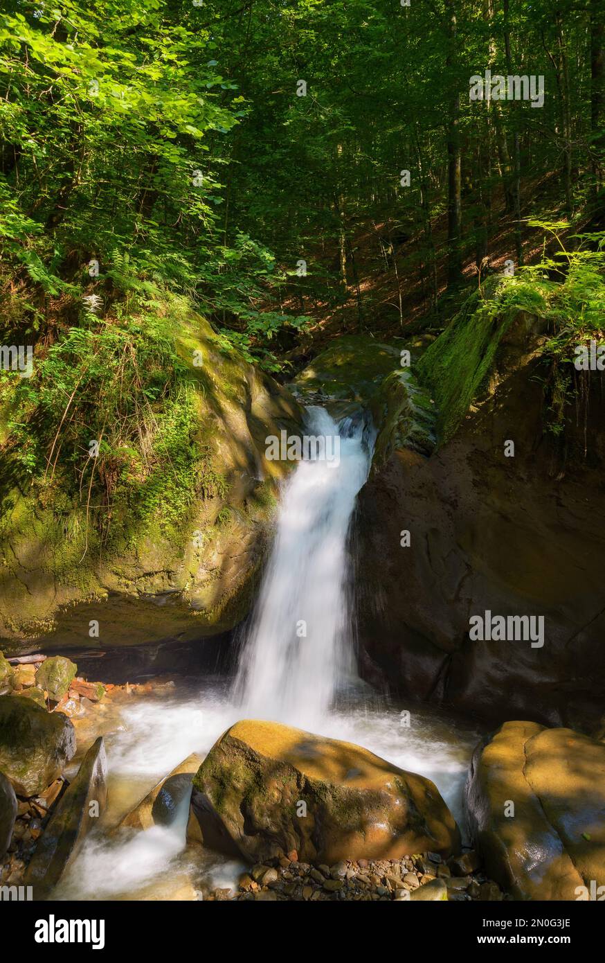 cascata sul torrente fuori di massi. estate paesaggio naturale nella foresta. rinfresco in una calda giornata estiva Foto Stock