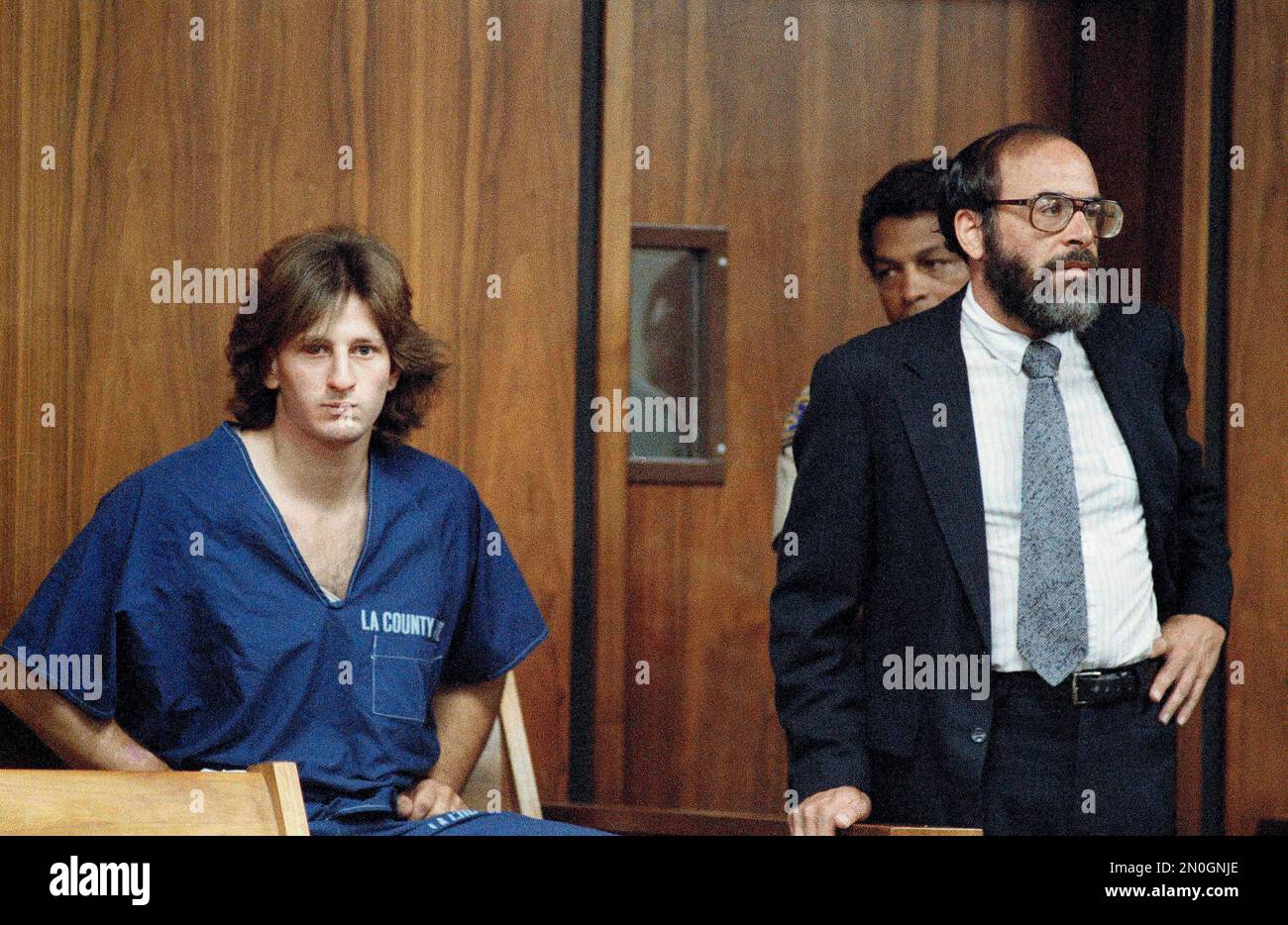 Steven Livaditis, left, listens in Beverly Hills Municipal Court, July 8, 1986, as his attorney, Deputy Public Defender Michael Demby, right, enters an innocent plea to three murders stemming from a bungled jewelry store robbery. Livaditis asked for a preliminary hearing as soon as possible. (AP Photo/Lennox McLendon) Foto Stock