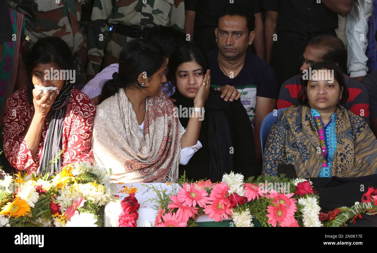 Wife Radhika, center, is consoled by a relative as she sits next to the ...