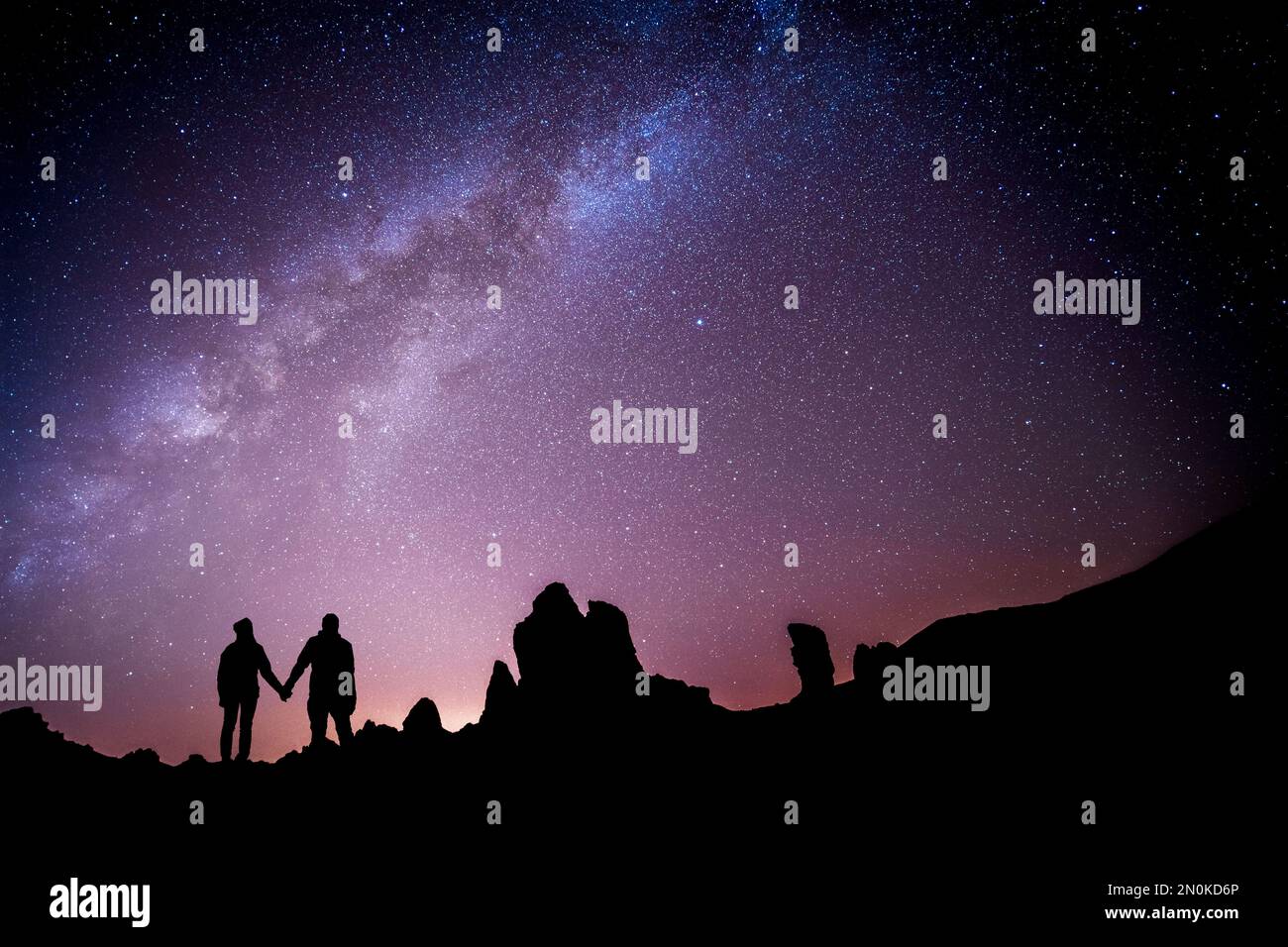 Coppia affettuosa di fronte al modo lattiginoso guardando le stelle. Metafora per l'astrologia zodiaca amore compatibilità Foto Stock