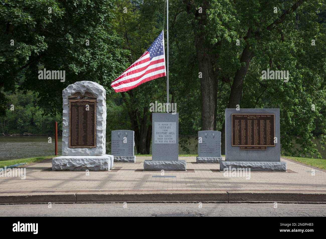 Memoriali di guerra, lapidi incise e bandiera americana in onore dei veterani di guerra statunitensi in un cimitero. Foto Stock