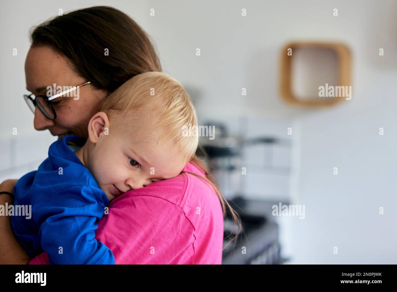 Testa di appoggio del bambino sulla spalla della madre Foto Stock