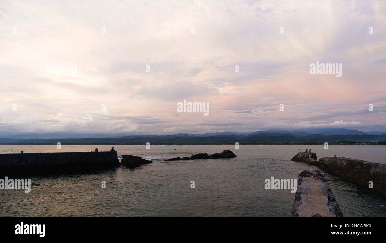 Vista mare pomeridiana, parete del mare, spiaggia e coralli, sfondo del tramonto sulla spiaggia di Santolo in Indonesia Foto Stock