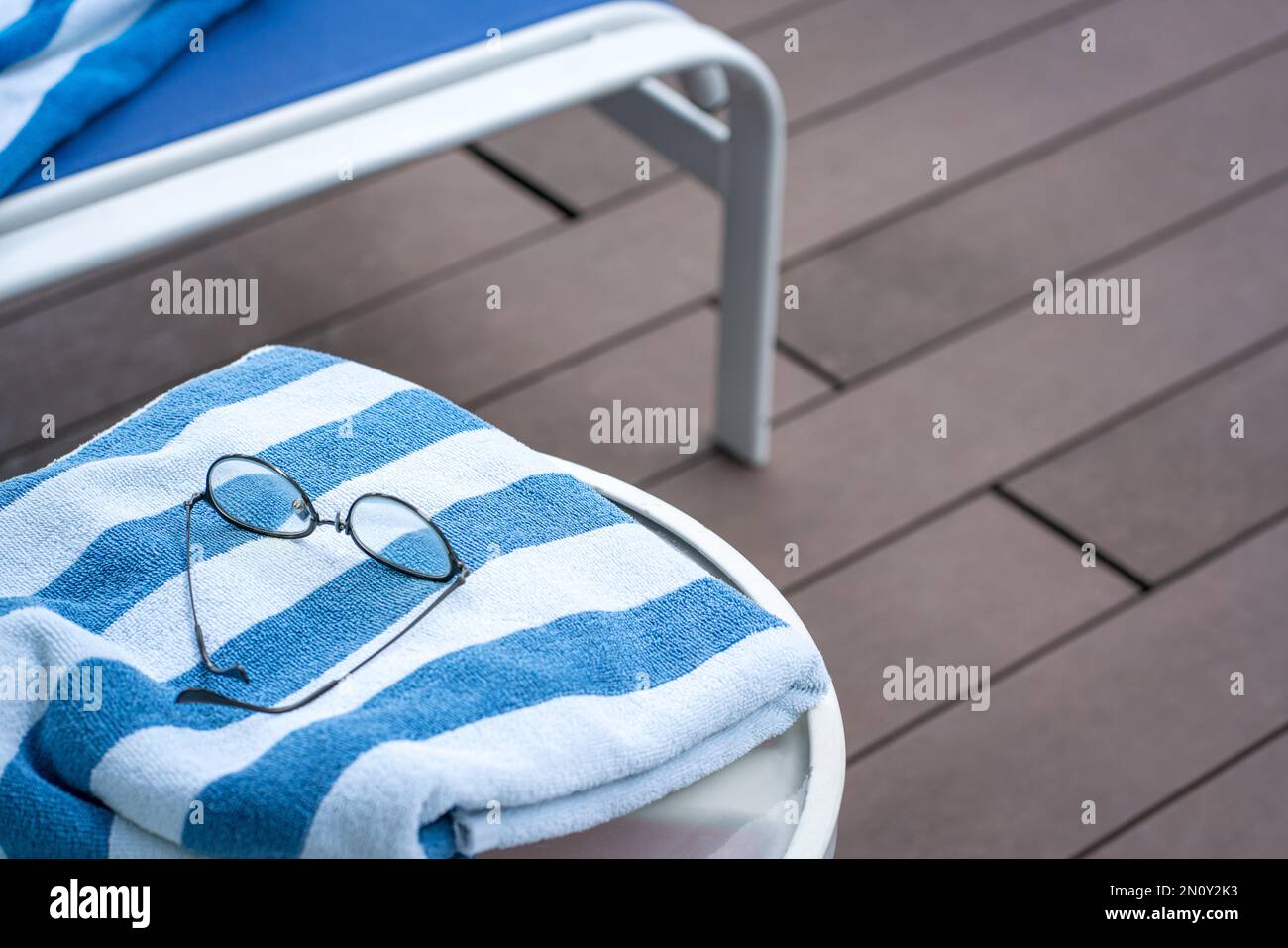 Telo da piscina sul tavolo e poltrona. Concetto di vacanza estiva. Foto Stock