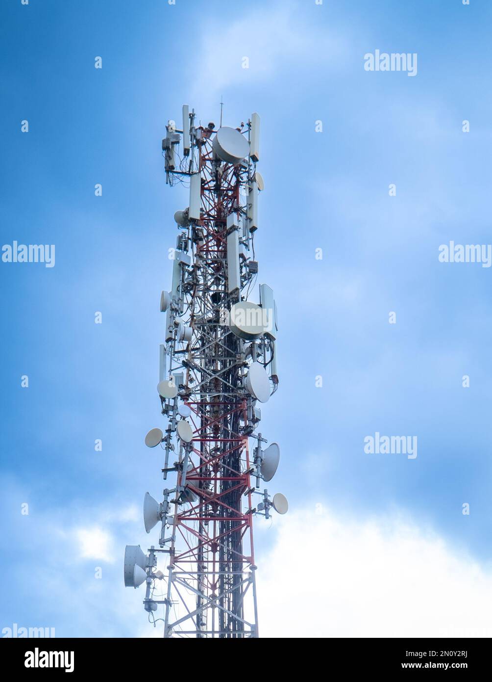 Torre per telecomunicazioni con cielo nuvole blu e bianche. Spazio di copia. Foto Stock