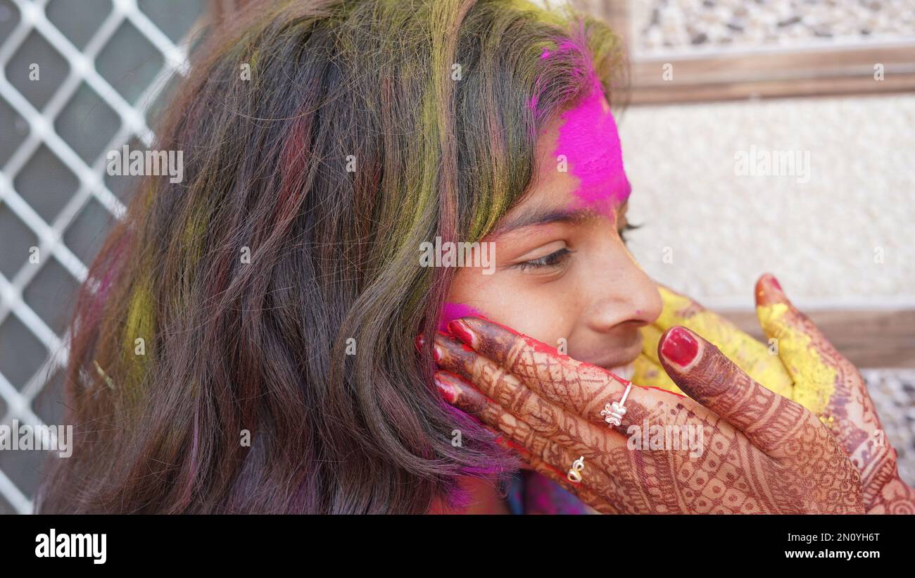 Madre felice godendo il tempo con sua figlia durante il festival holi a casa Foto Stock