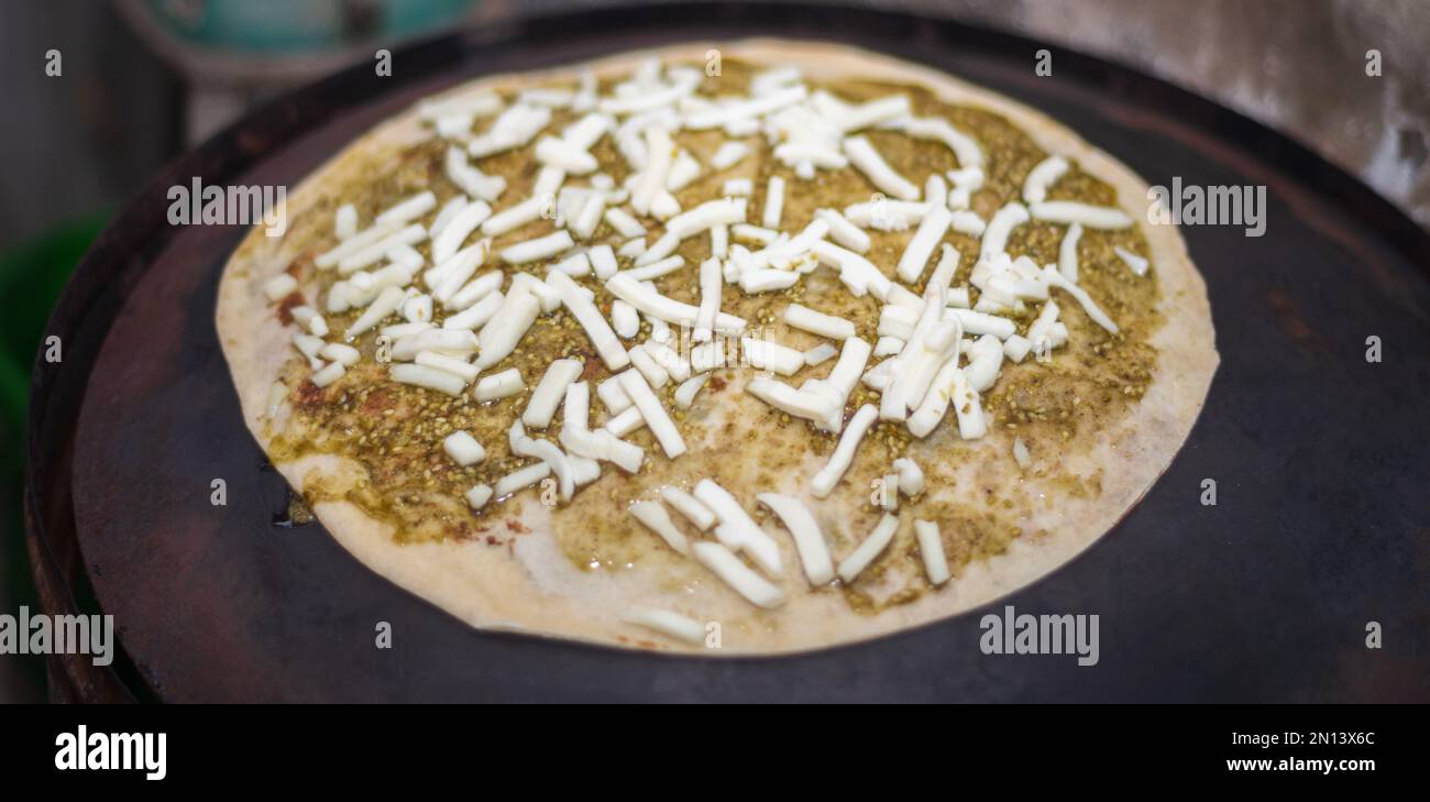 Tostare quesadillas di formaggio su una griglia calda. Formaggio e pasta piccante come condimento per la tortilla. Foto Stock