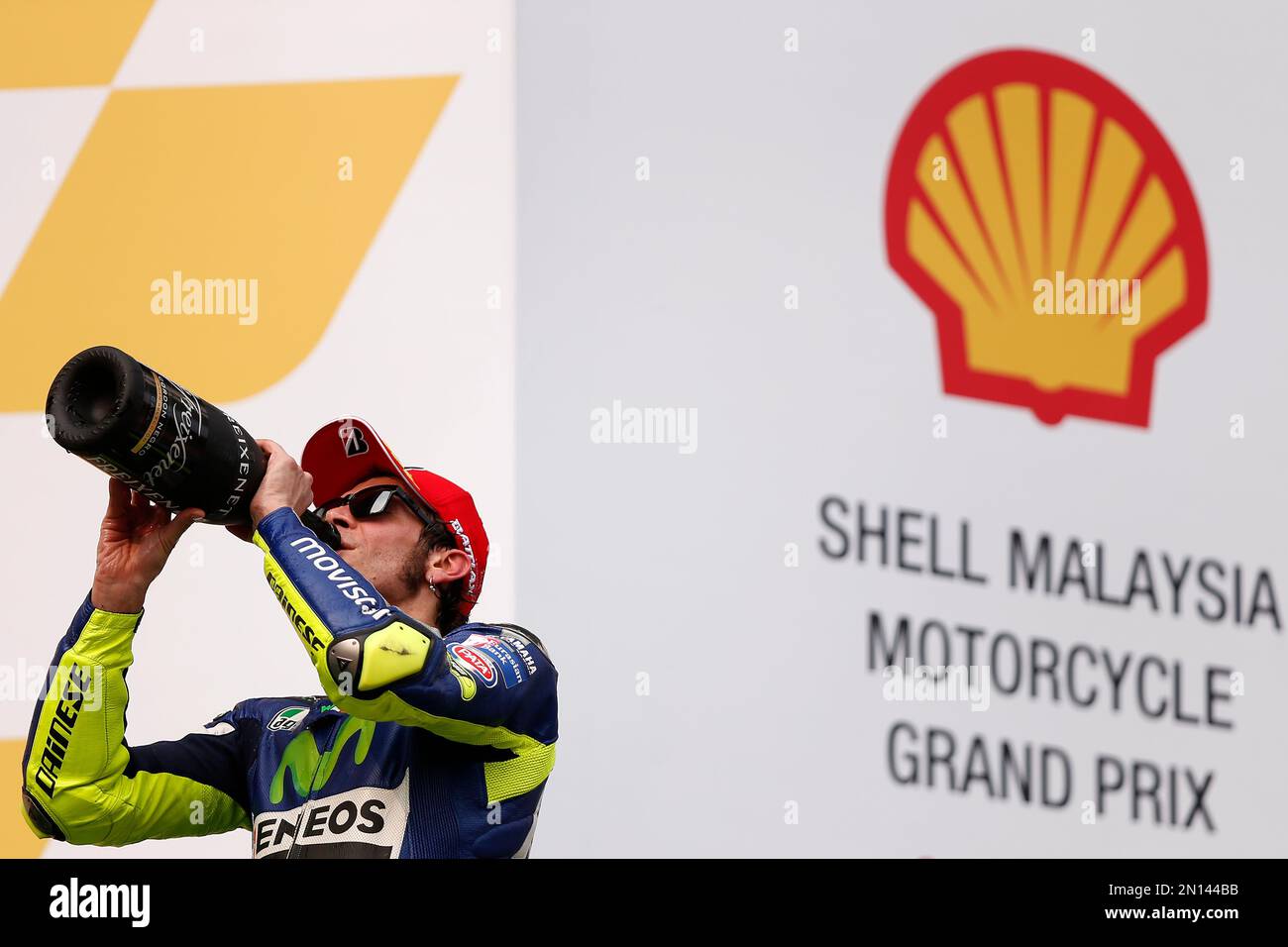 MotoGP rider Valentino Rossi of Italy drinks champagne after finishing third at the Malaysian Motorcycle Grand Prix at Sepang International Circuit in Sepang, Malaysia, Sunday, Oct. 25, 2015. (AP Photo/Lai Seng Sin) Foto Stock