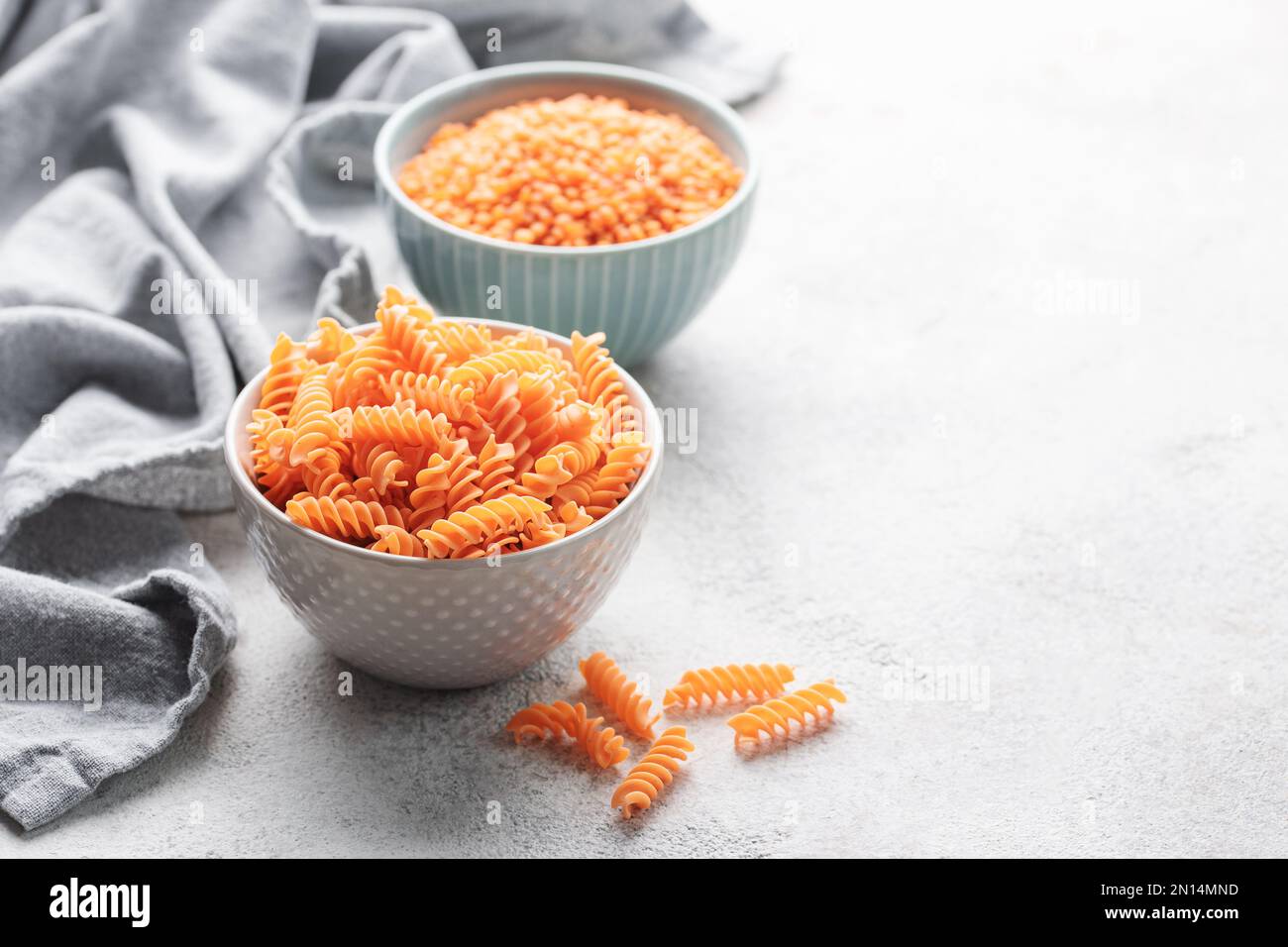 Lenticchie rosse fusilli. Ciotola con pasta cruda e lenticchie rosse. Pasta senza glutine. Foto Stock