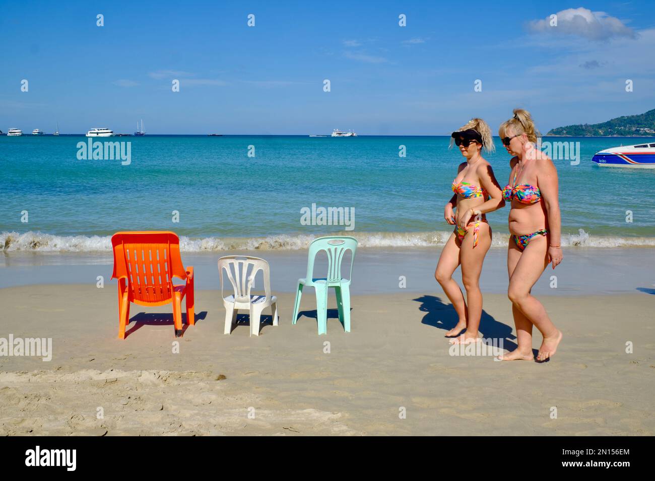 Due donne turisti occidentali camminano lungo Patong Beach, Phuket, Thailandia Foto Stock